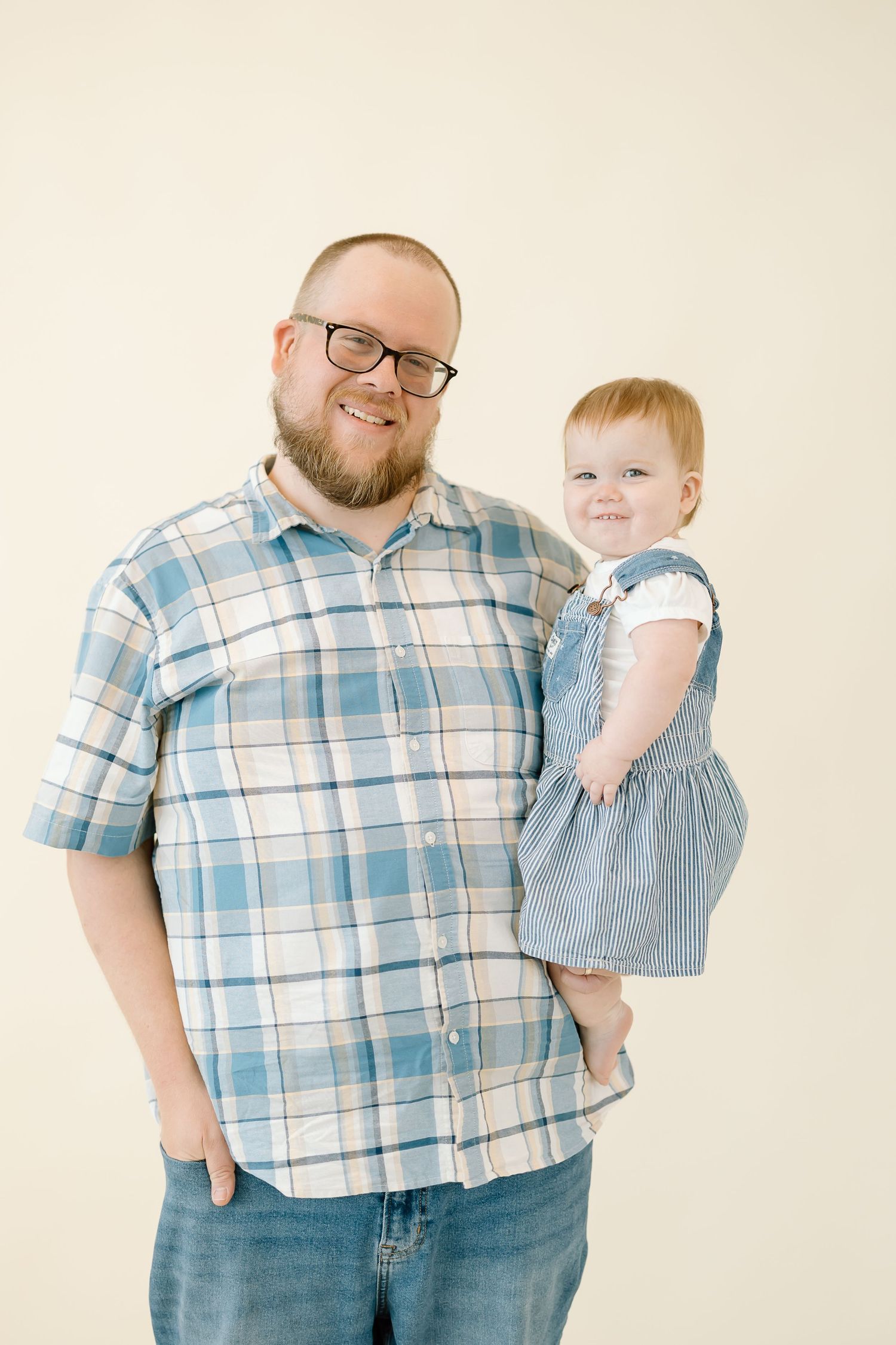 A series of four studio portraits showing a parent and small child in coordinating blue and white outfits against a light background.