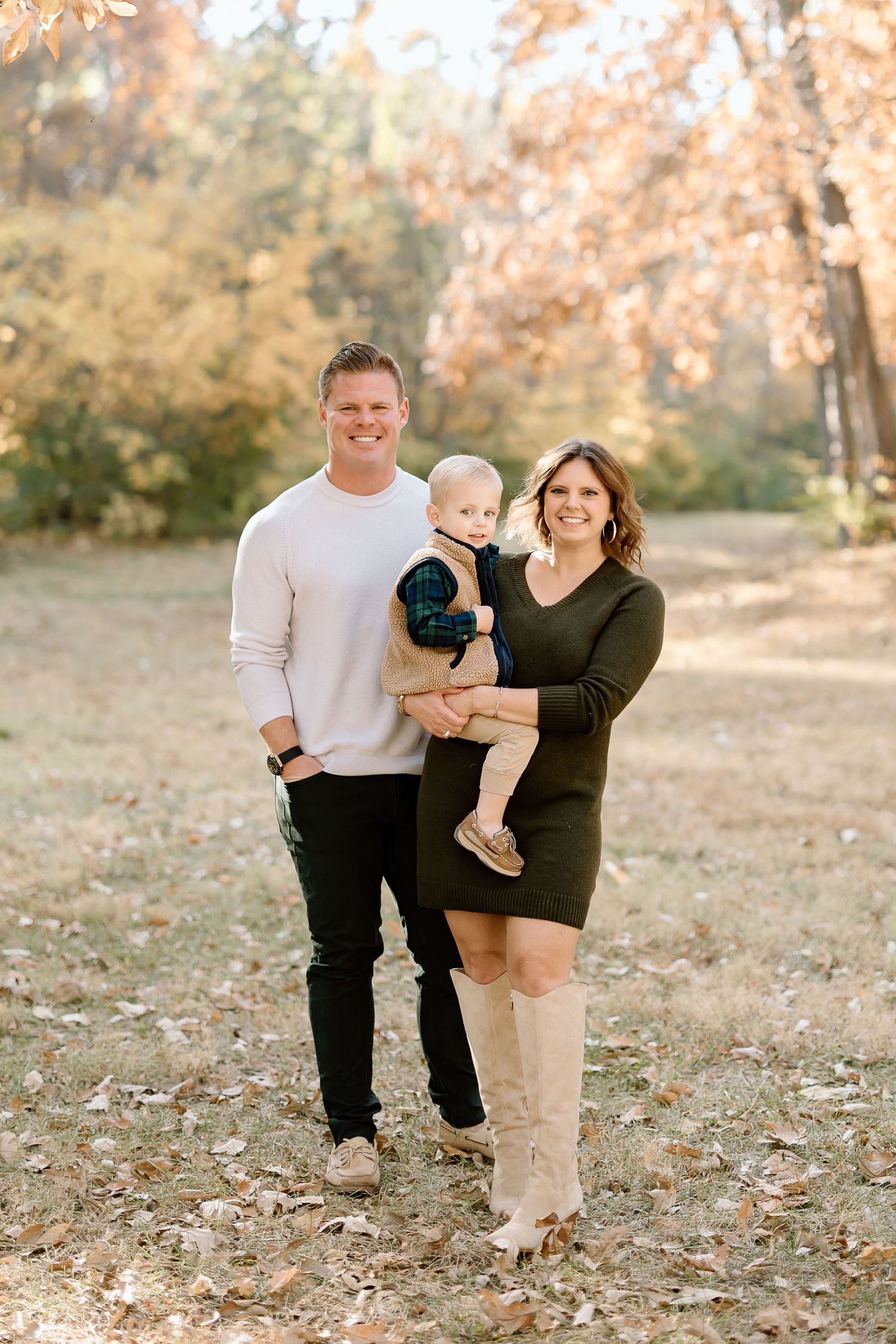Family poses together in coordinated outfits during autumn photo session.