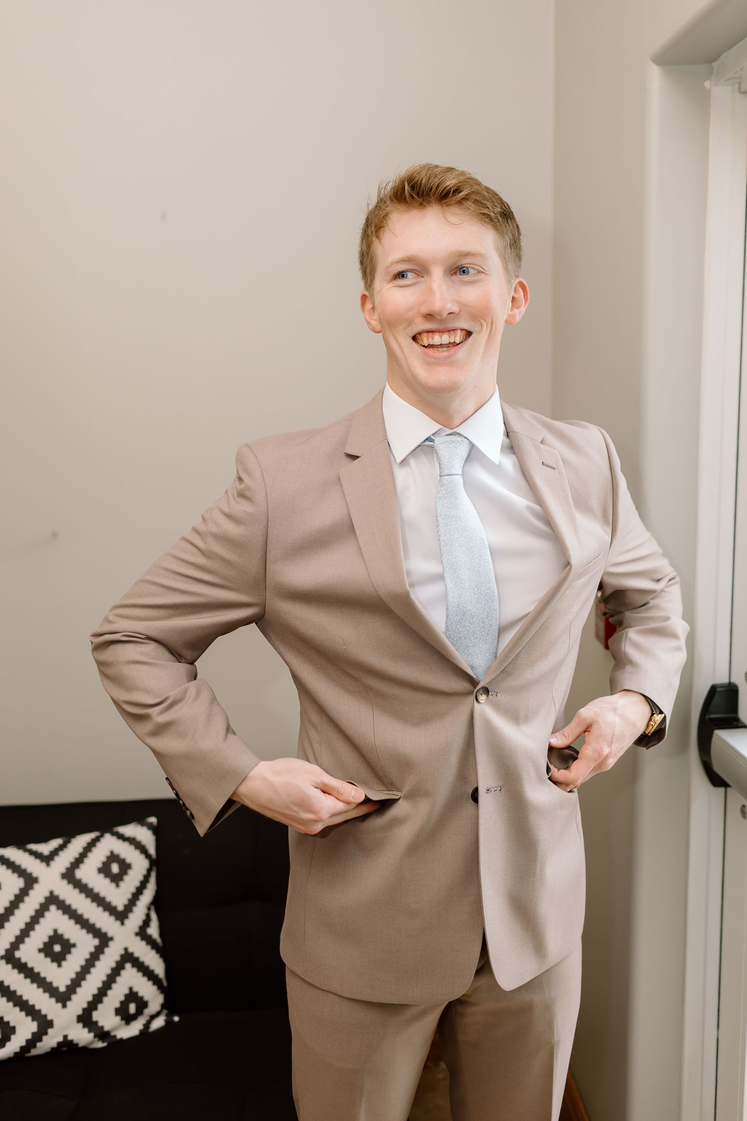 A young person in a beige suit and light blue tie poses playfully in a sequence of connected photos.