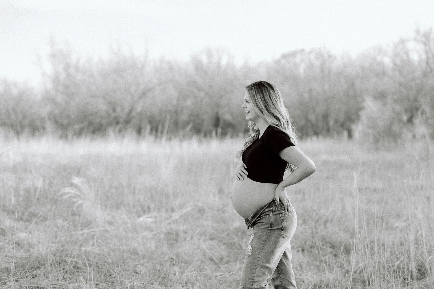 Black and white panoramic sequence shows a person dancing and twirling through a misty meadow at sunrise.