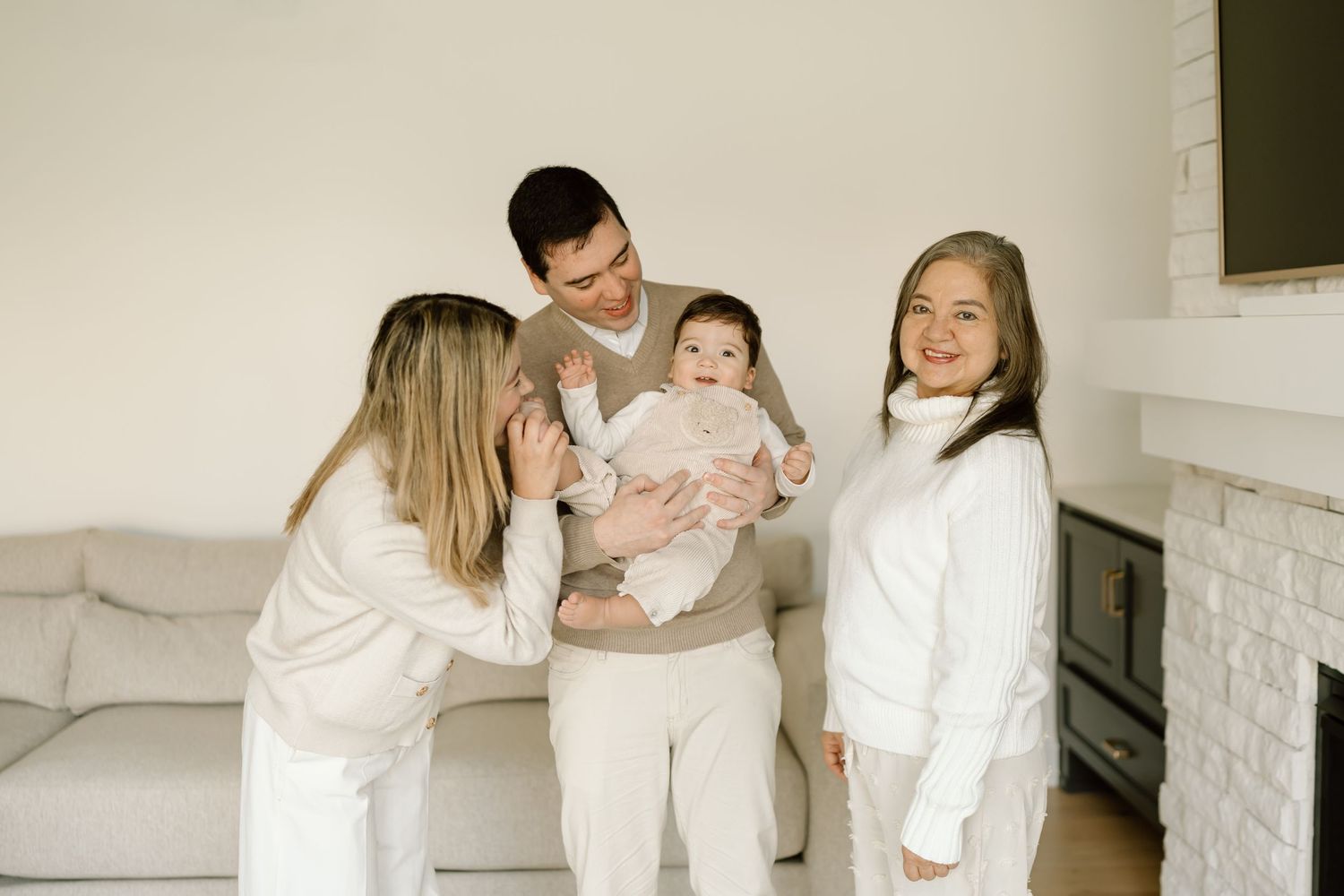 A collection of photos showing a family in white clothing sitting together on a couch in a bright, minimalist setting.