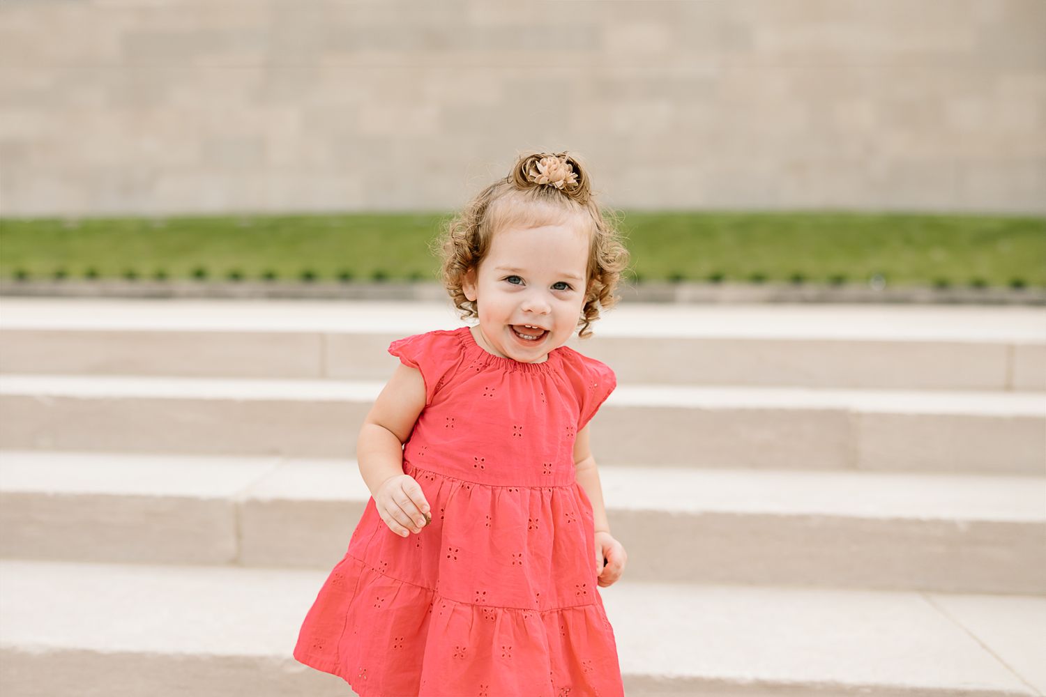 A series of photos showing a small child in a bright coral dress running and playing outdoors.