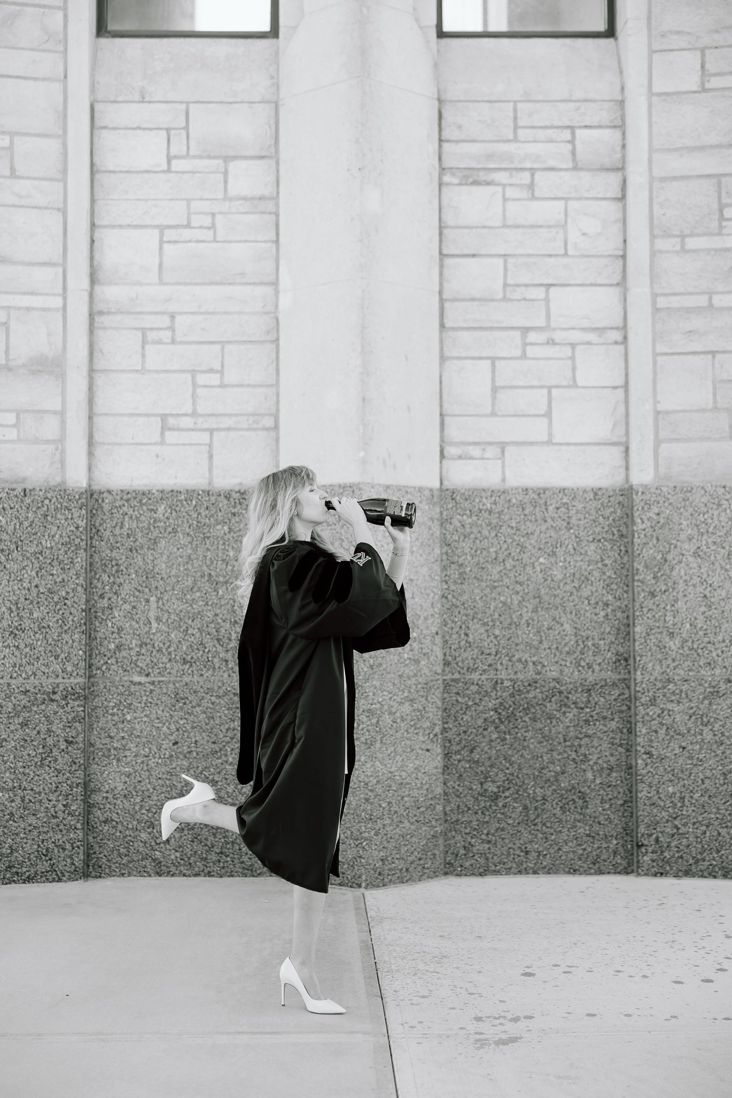 Black and white triptych showing a person in dark clothing against a stone wall with a white high heel shoe.