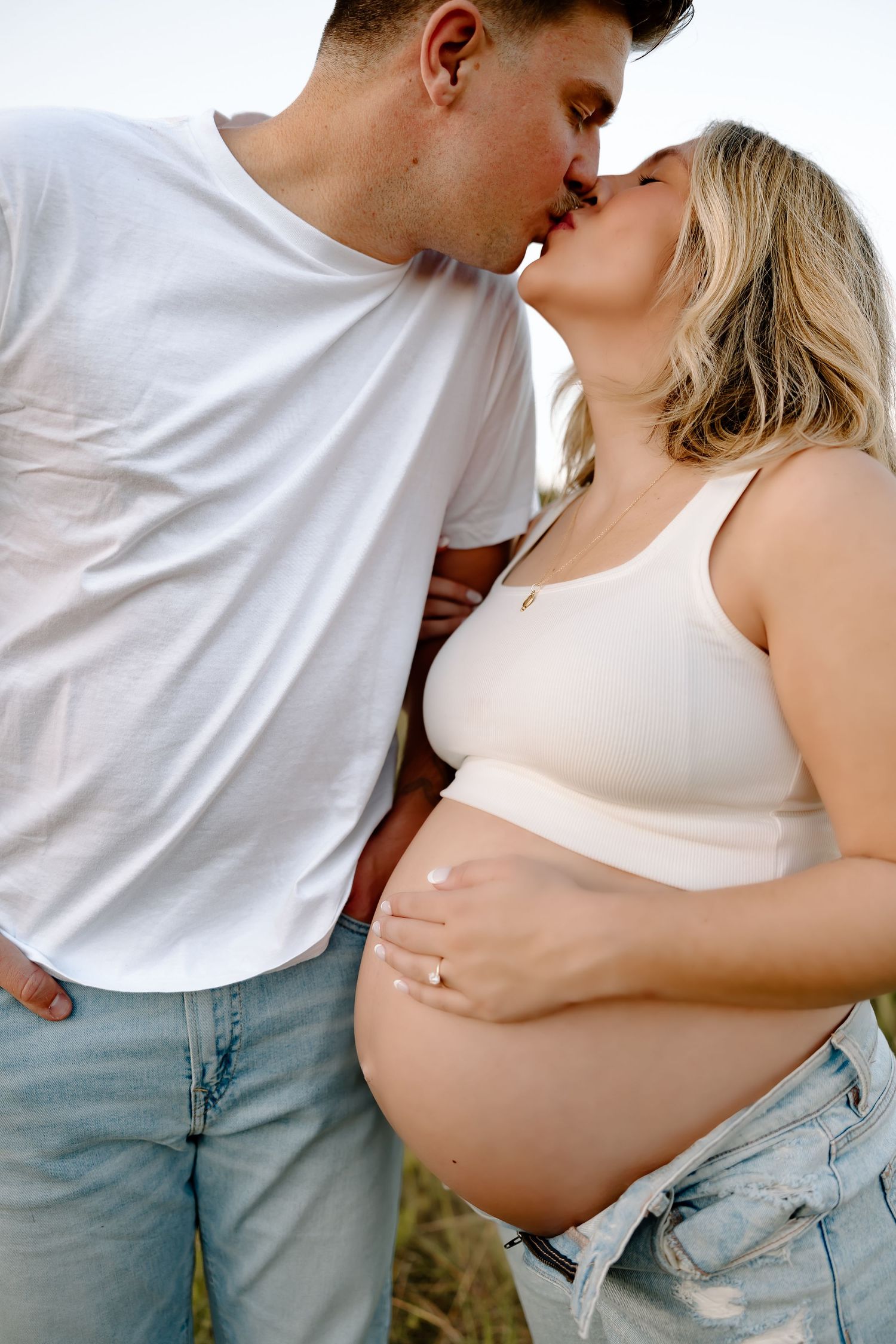 Romantic couple in casual white shirts and jeans share tender kisses in a series of intimate photos.