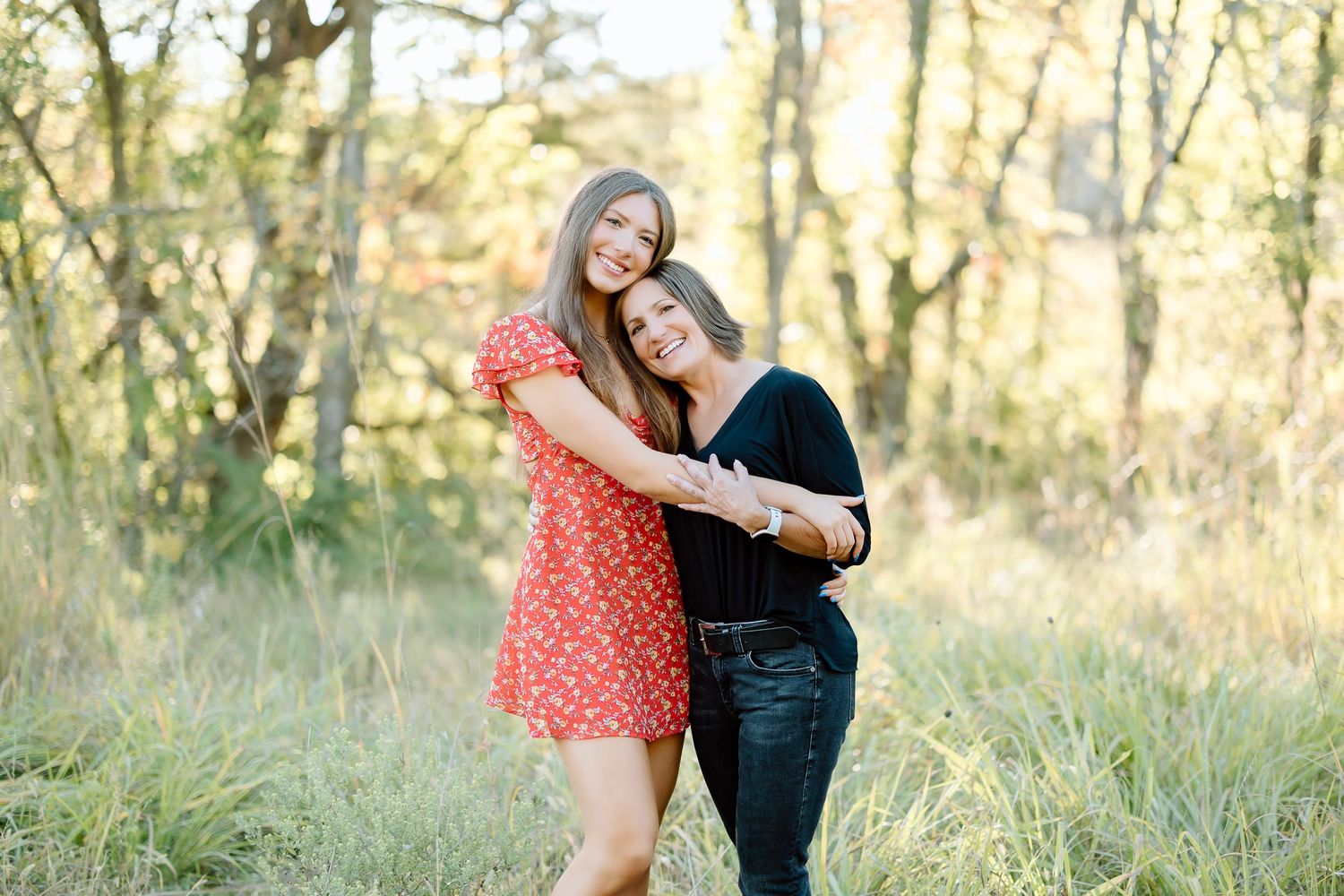 A couple shares tender moments in a sunlit field during a romantic outdoor photo session.