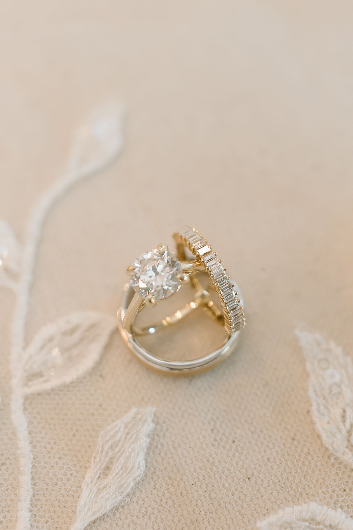 Close-up view of a sparkling diamond engagement ring with delicate lace details in the background.