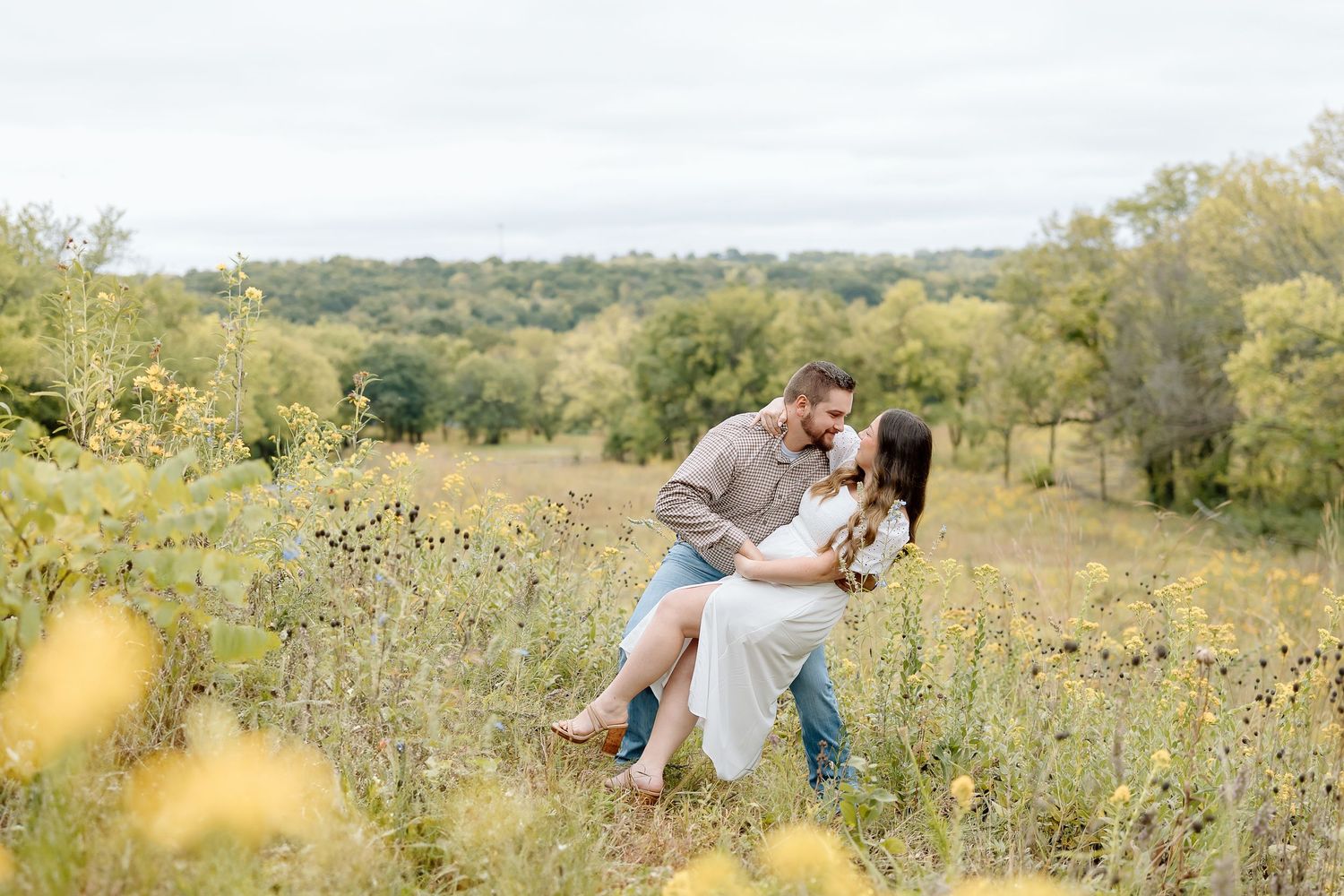 Romantic couple sharing an intimate moment while dancing in a wildflower field.