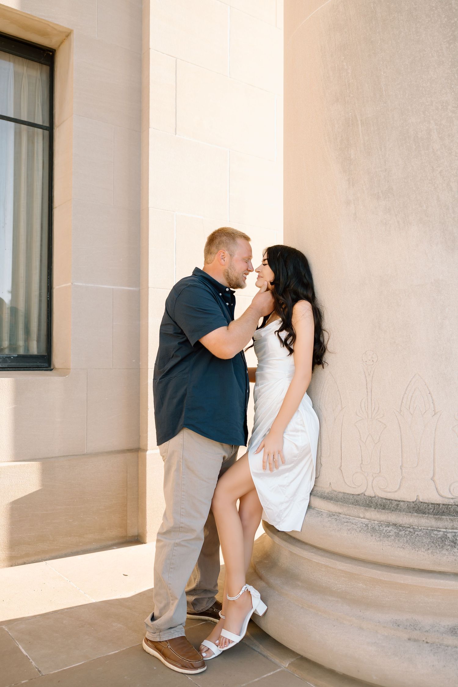 A romantic couple shares intimate moments in a series of photos against a white columned building exterior.
