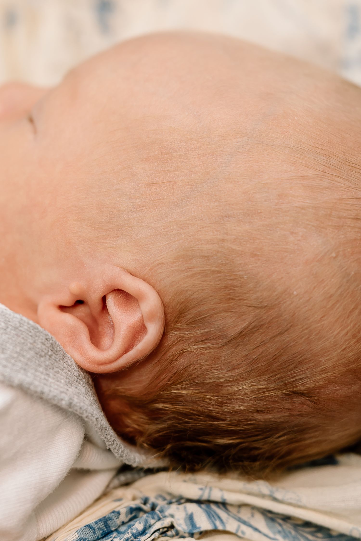 Close-up view of a sleeping baby's head resting on a floral patterned pillow.
