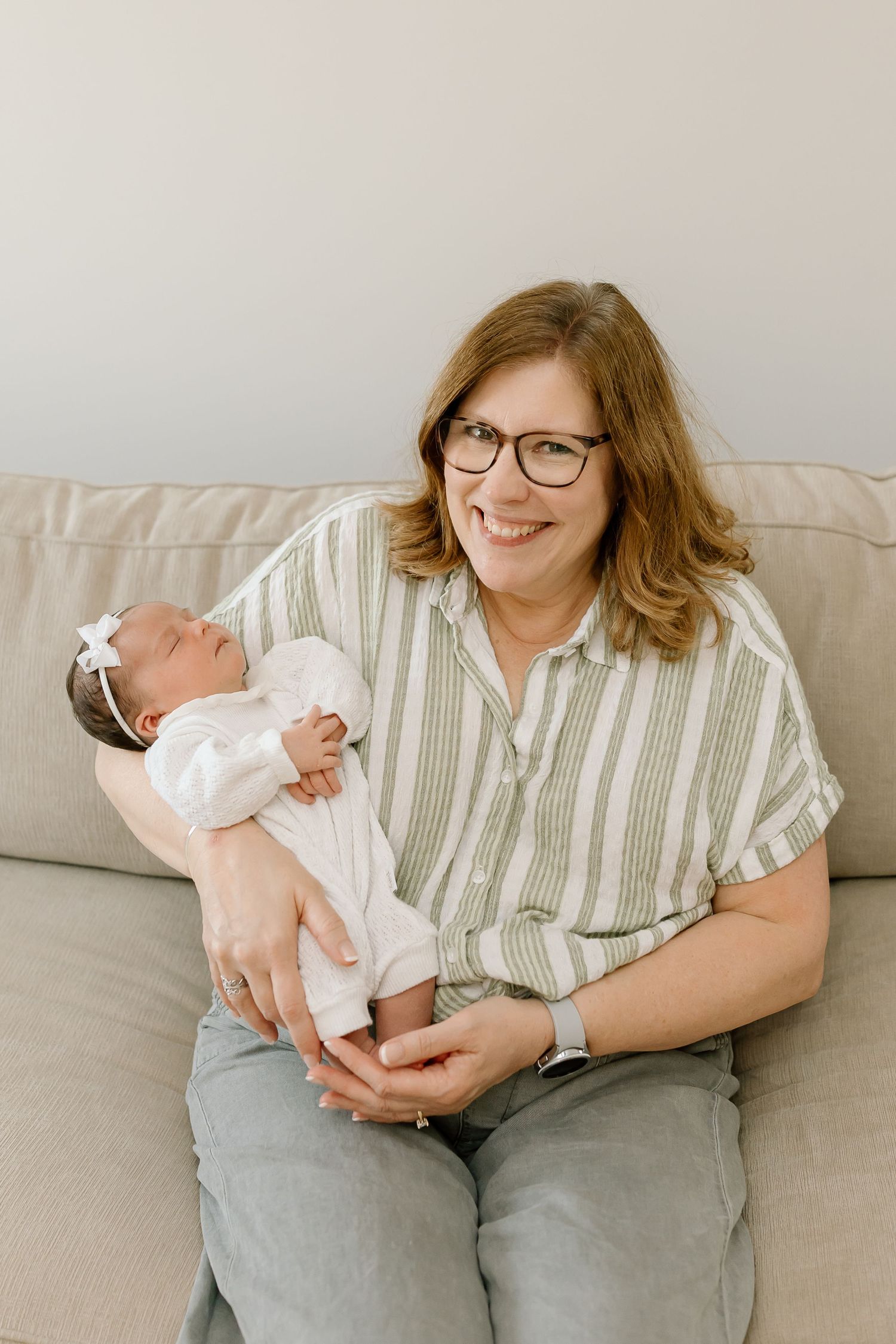 A series of candid photos showing tender moments between a caregiver and an infant on a gray couch.