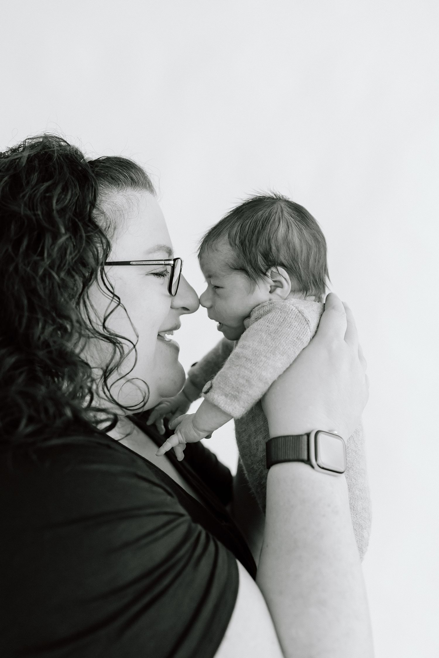 Black and white photo series showing tender moments between a parent and child in close-up profile views.