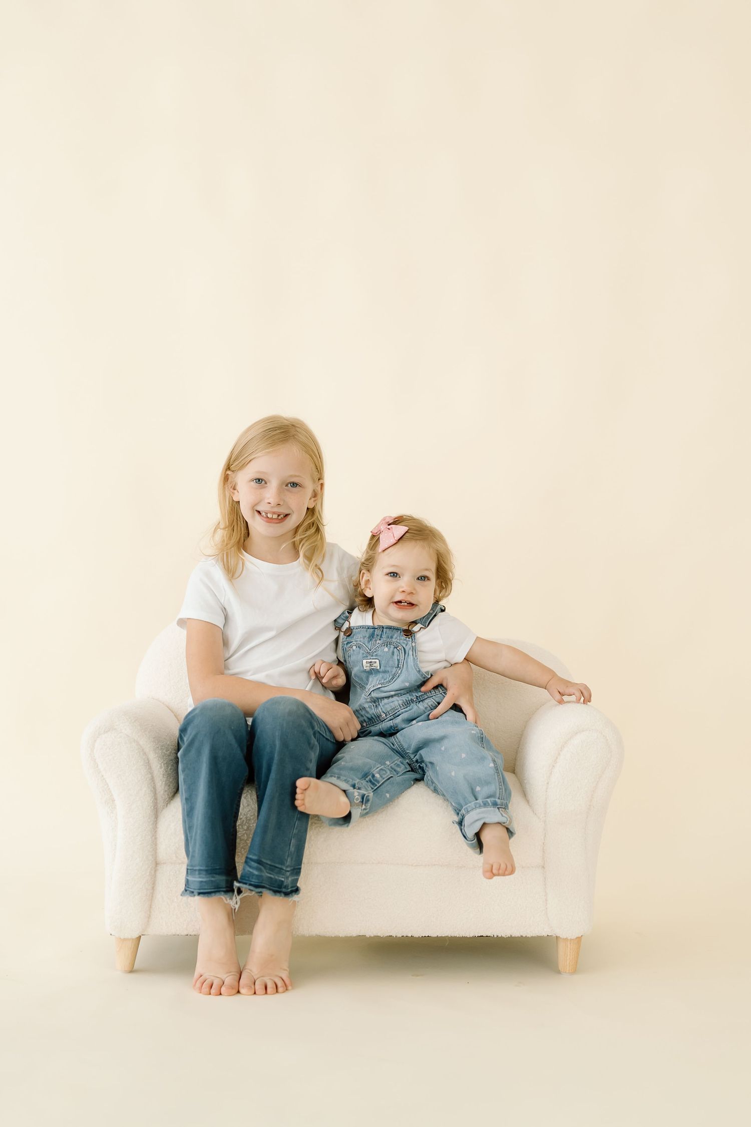Three connected photos showing children sitting and playing together on a white couch against a light background.