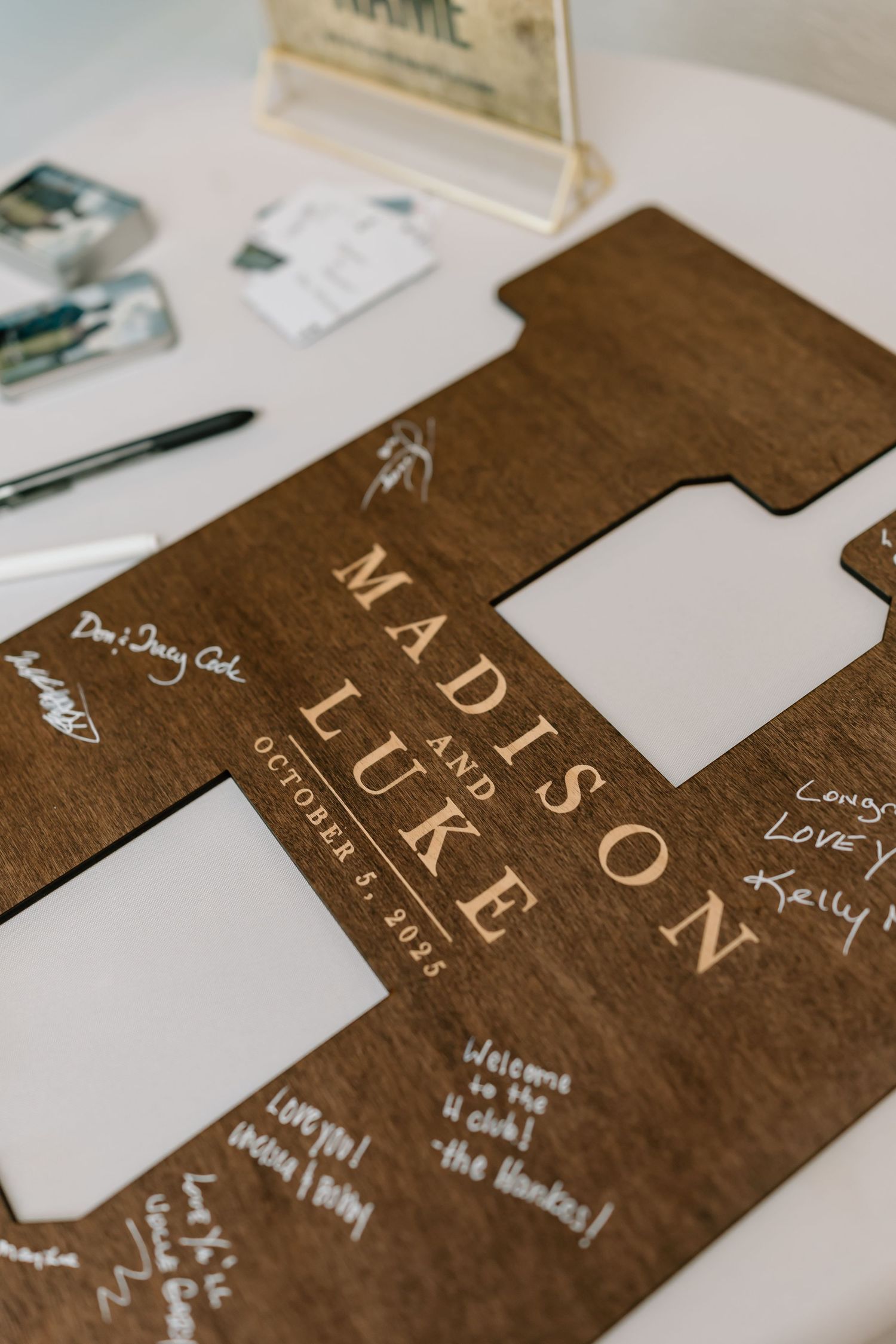 Close-up view of dark brown wooden boards with engraved text and signatures in white ink.