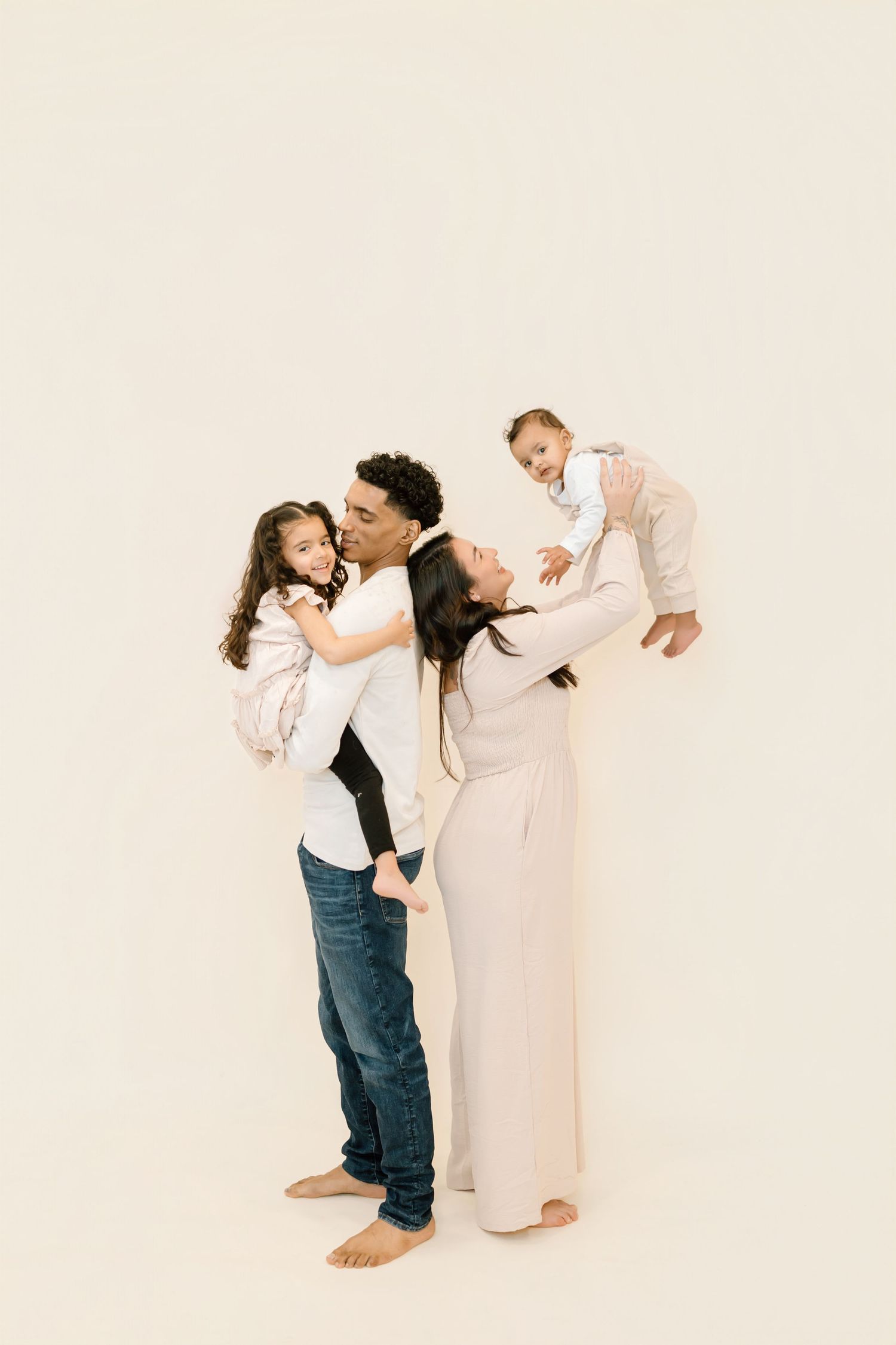 A series of four artistic family photos showing playful interaction between parent and child against a light background.