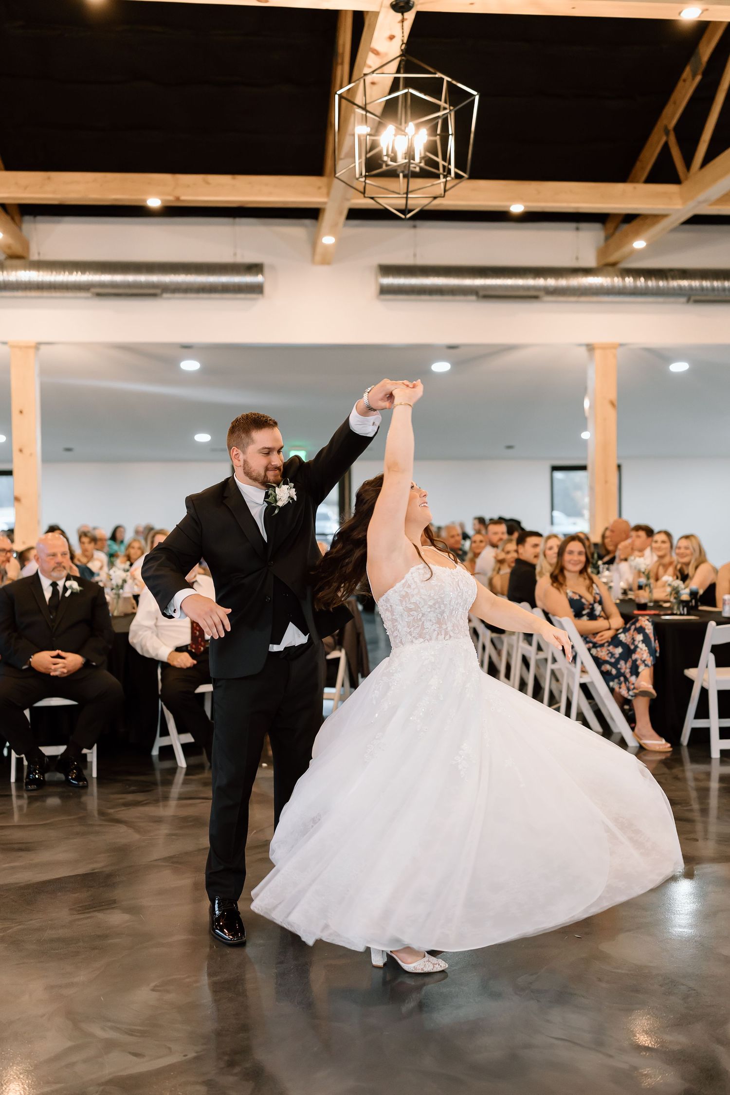 Wedding couple performs a romantic dip dance move on the dance floor during their reception celebration.