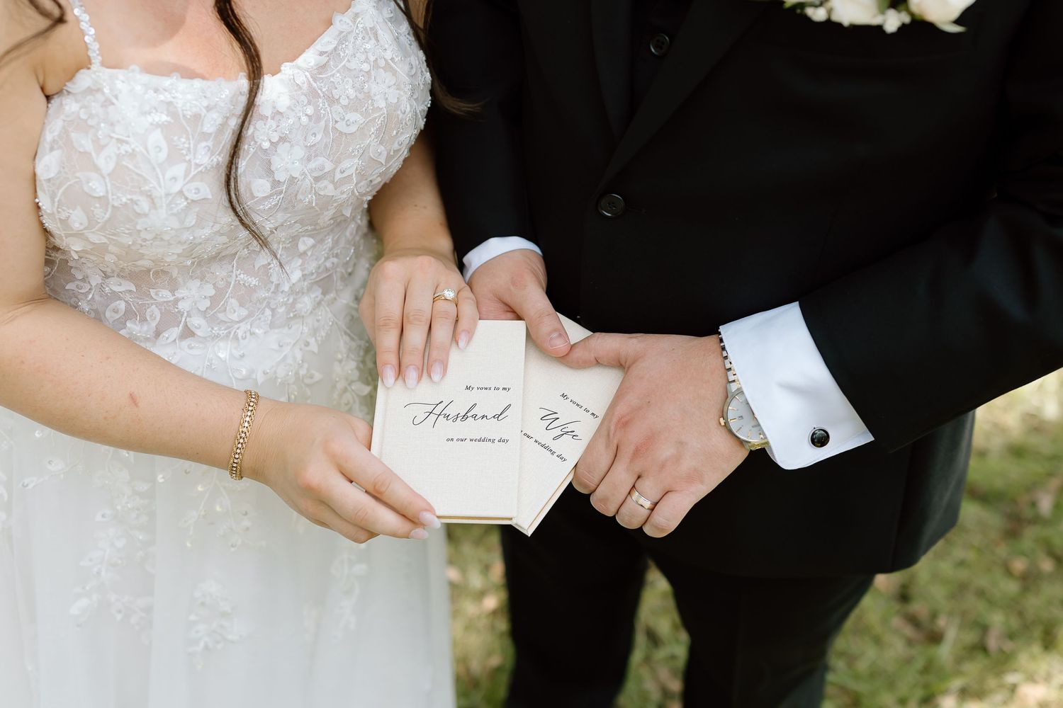 A close-up shot of a couple exchanging personal letters during their wedding ceremony outdoors.