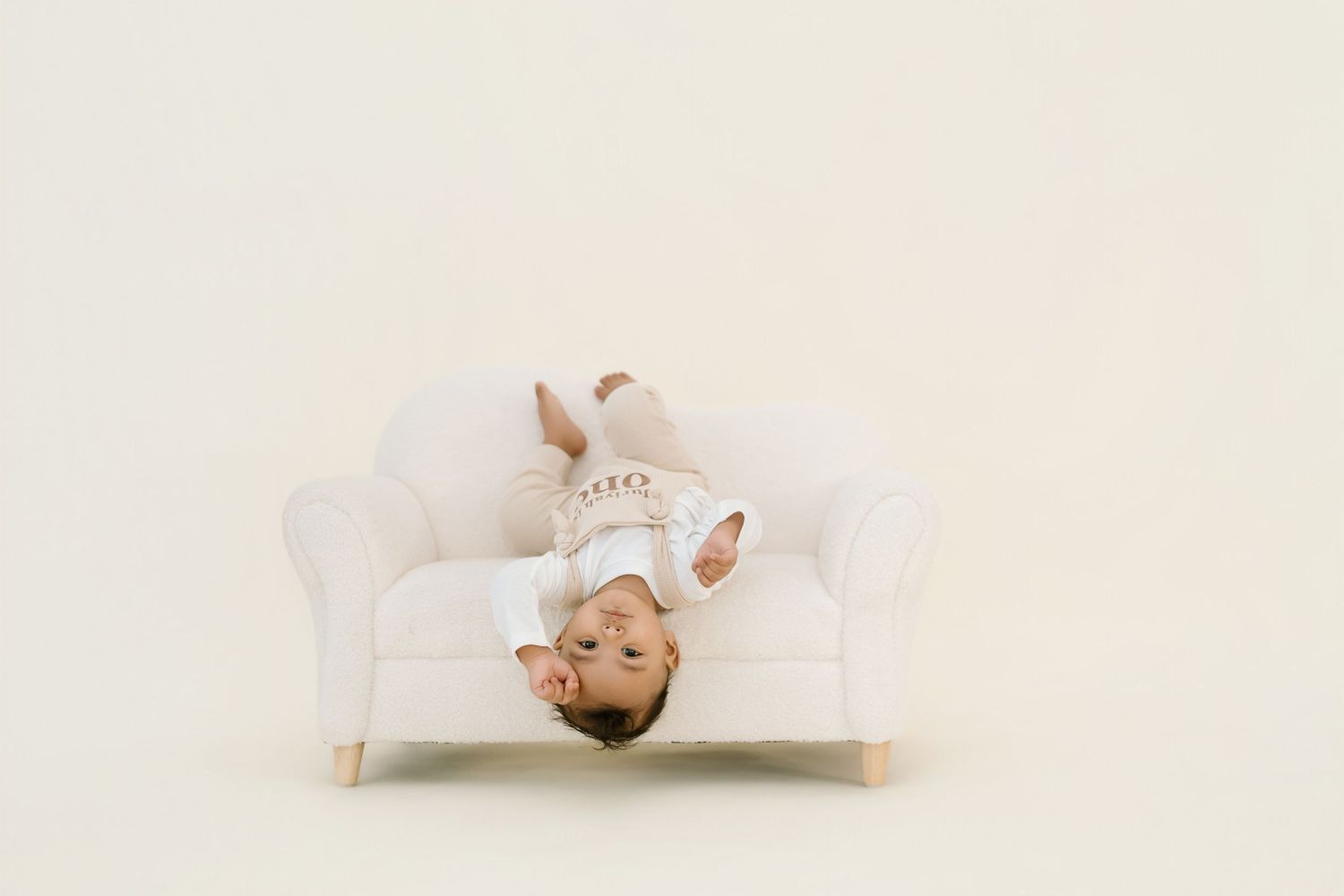 Minimalist white maternity photo session on light background.