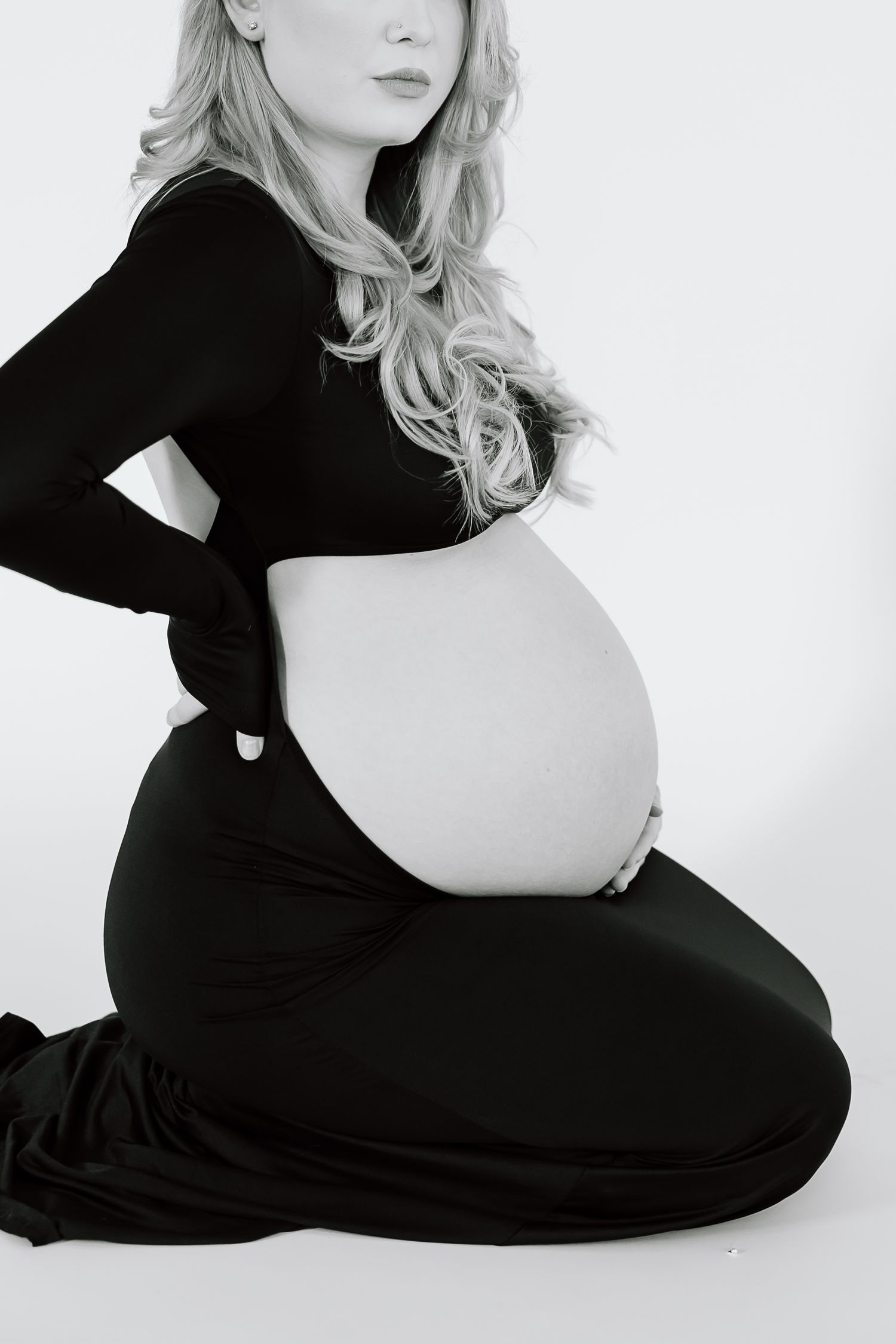 Artistic black and white maternity photo showing silhouette in profile view.