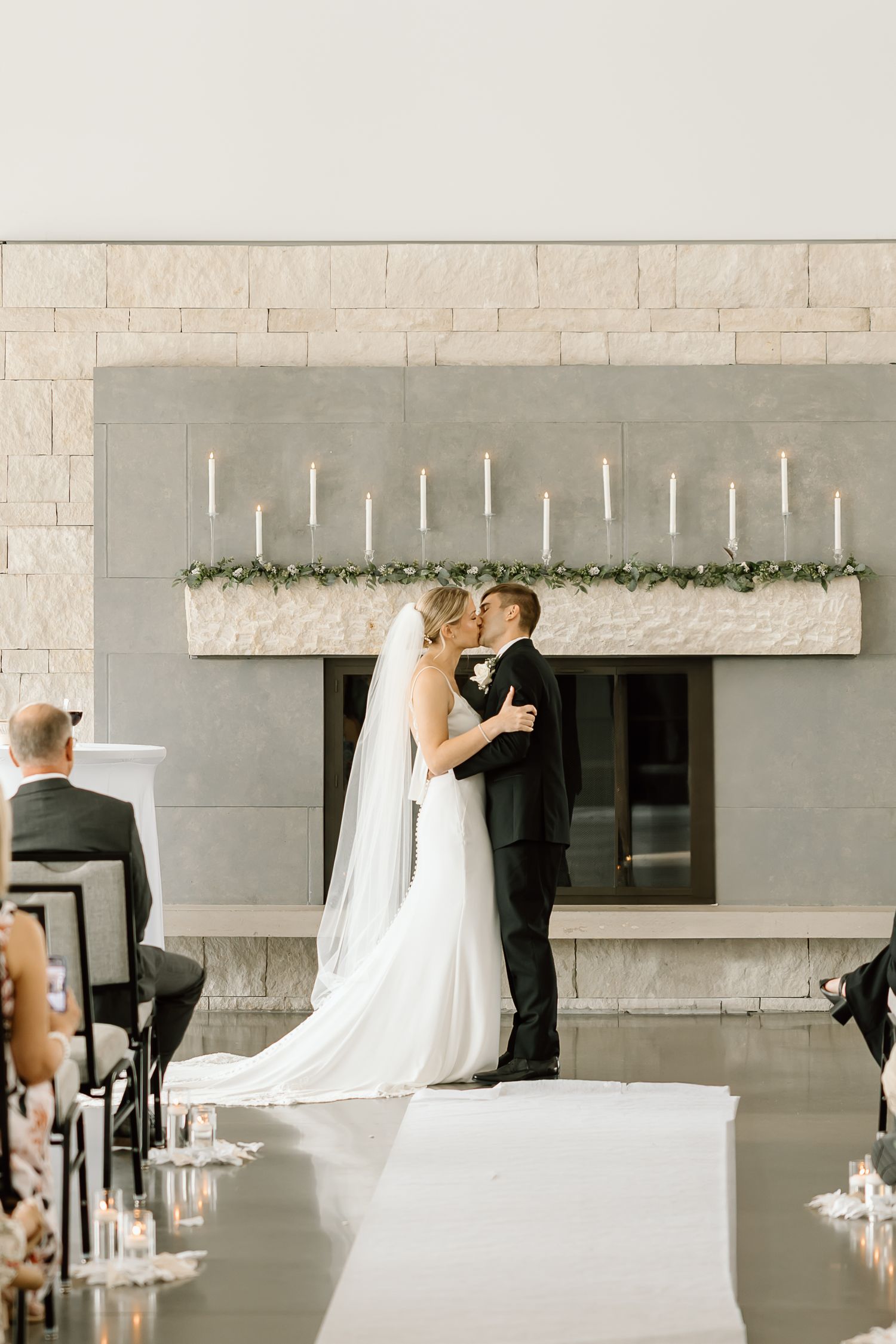 A couple shares a romantic moment during their modern minimalist wedding celebration at a sleek venue with white decor.