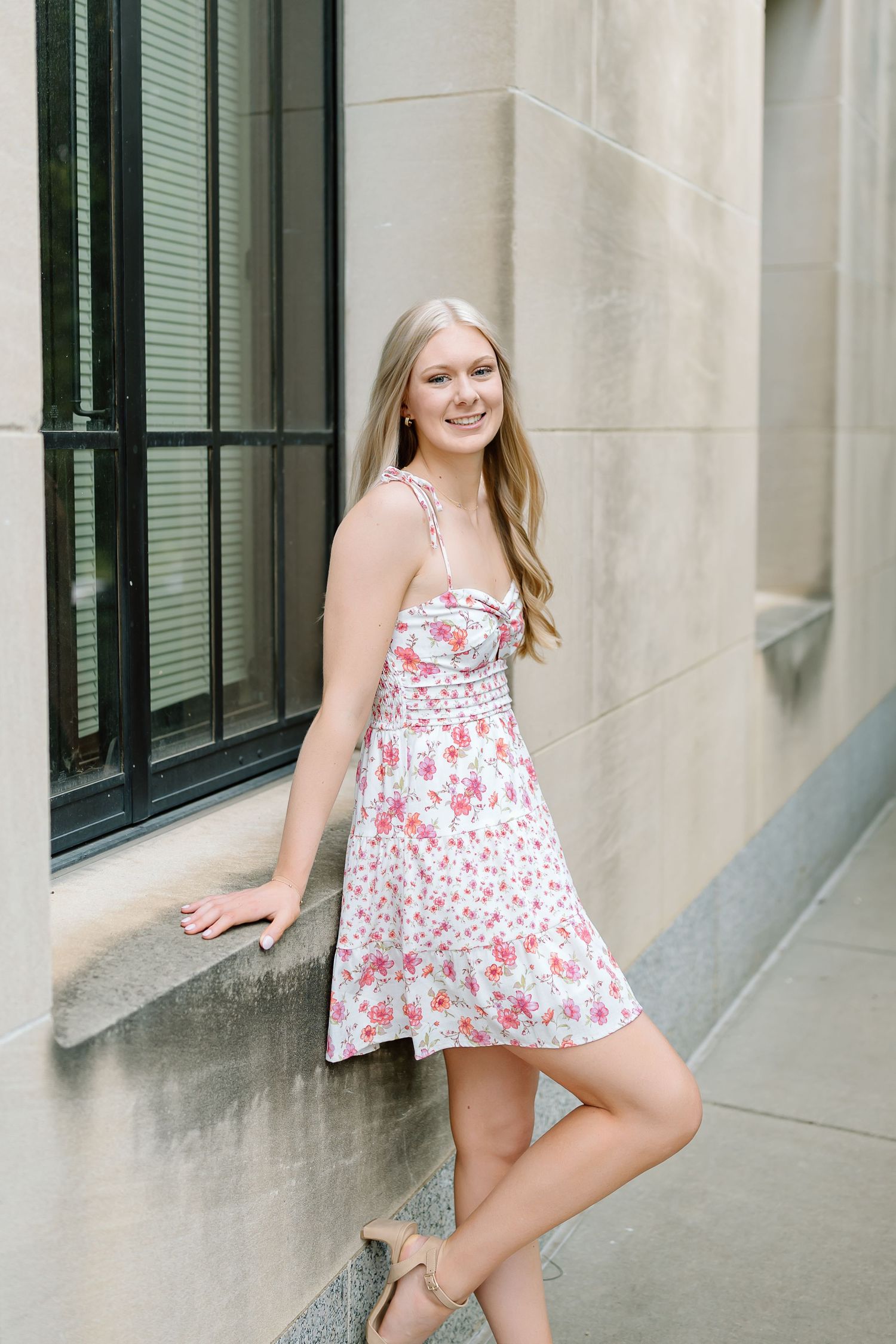 A series of outdoor portraits against a beige wall with green shuttered windows in casual summer attire.
