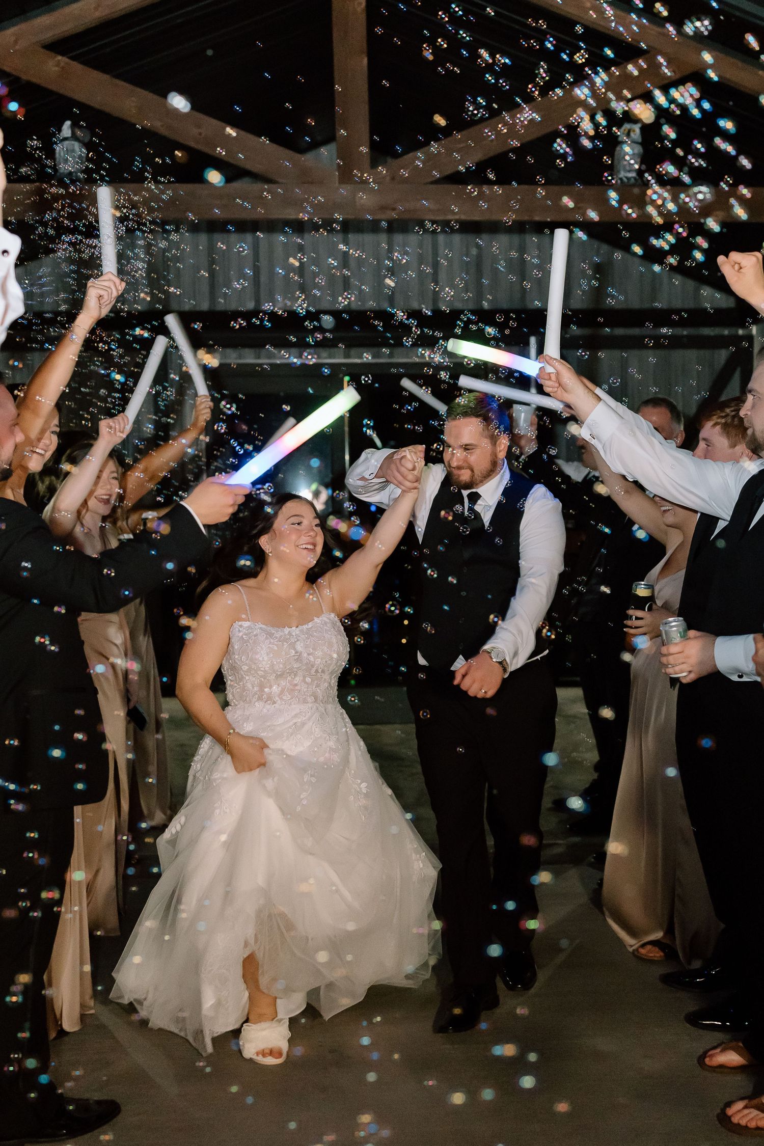 Wedding party celebrates with confetti and sparklers during a joyful nighttime reception exit sequence.