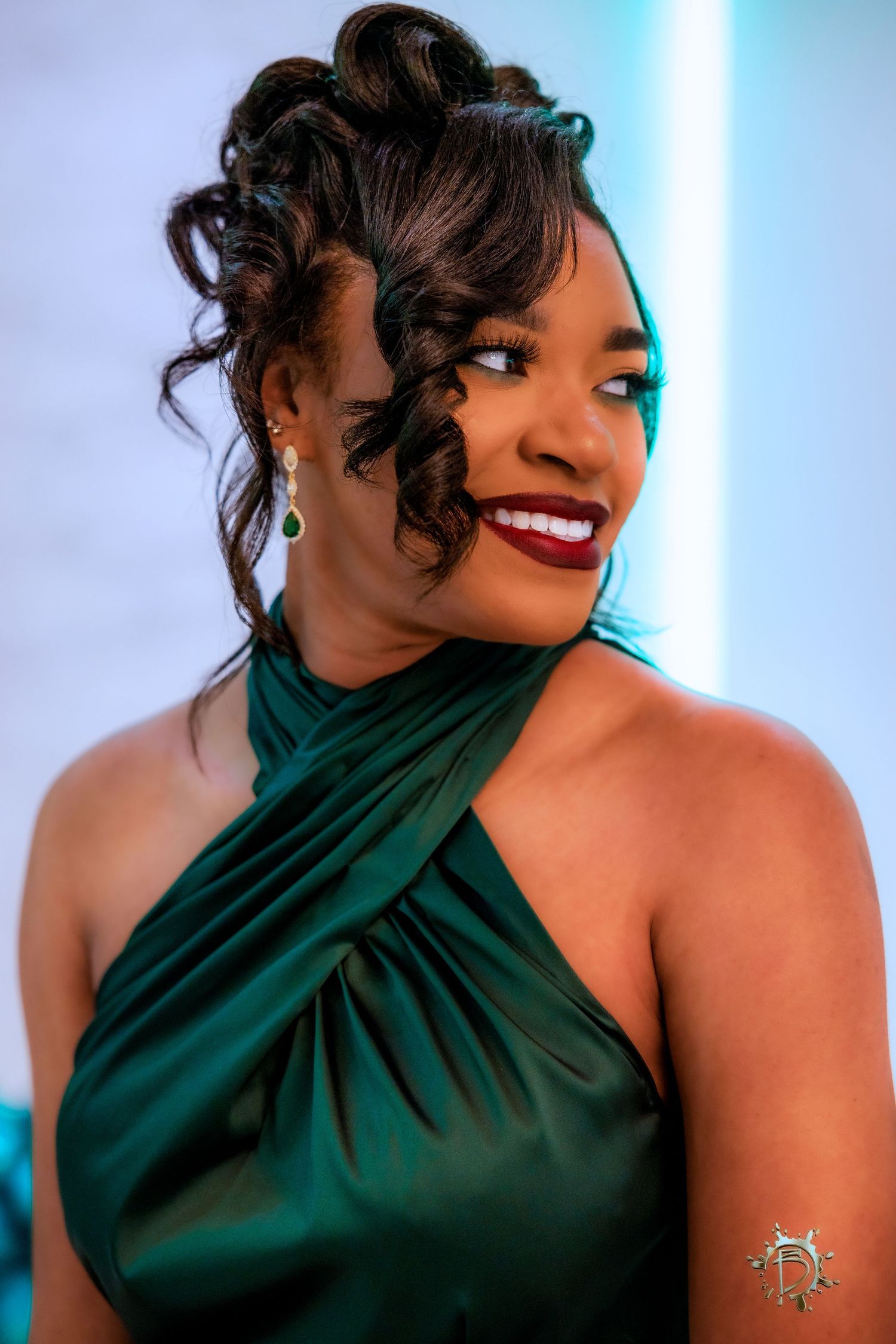 Sequence showing model in emerald green halter dress posing against light backdrop with red lipstick and curled updo.