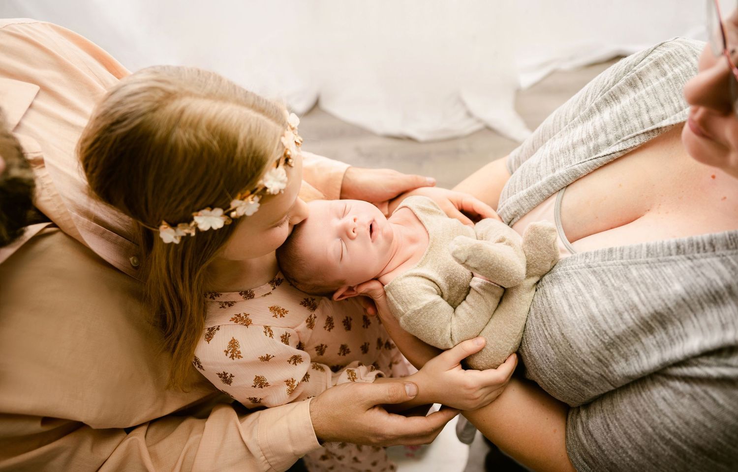 Five connected images show tender moments of parent and baby holding hands in warm, sepia-toned photography.