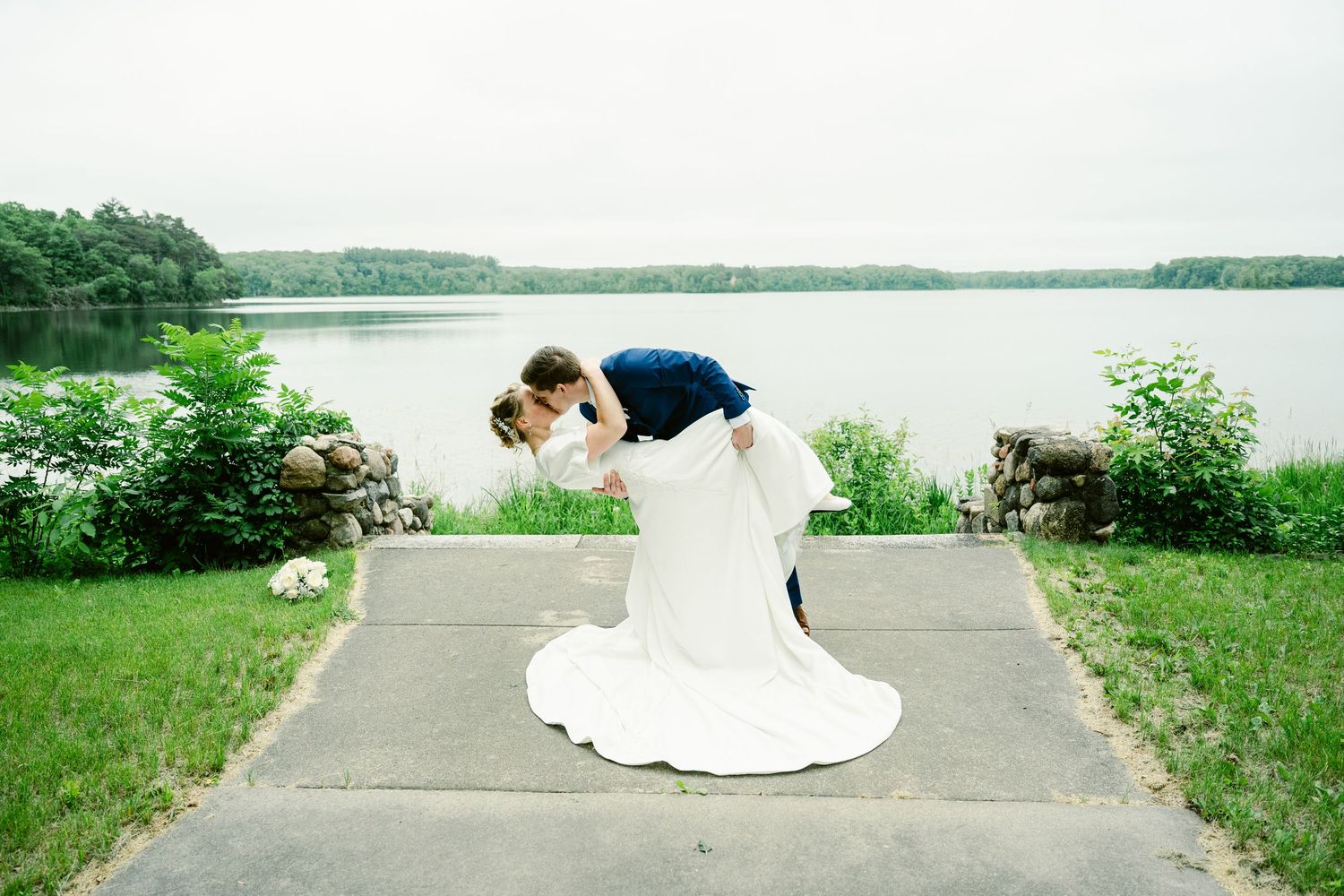 Wedding photography session on a lakeside path with scenic water views.