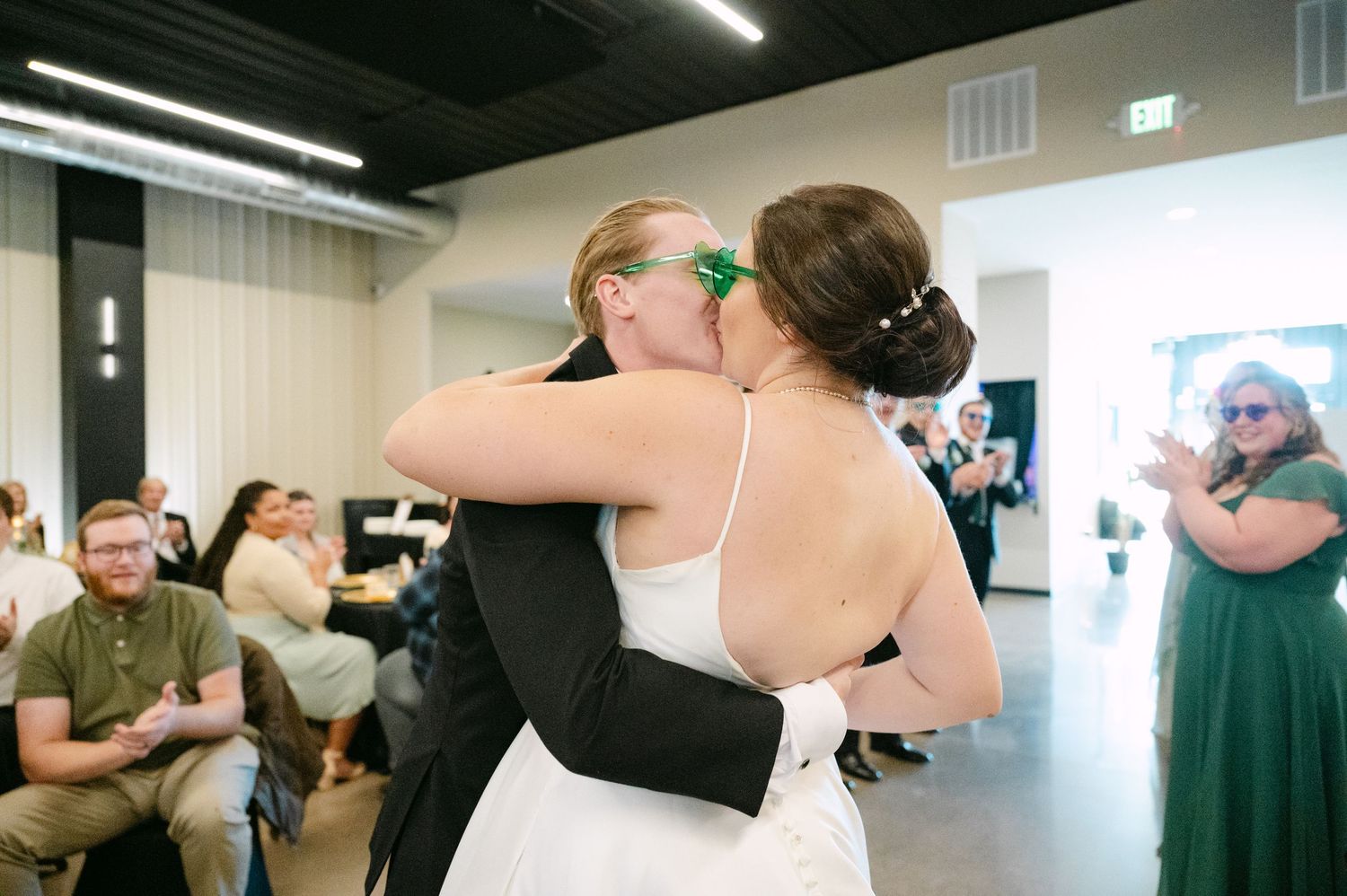 Guests share intimate moments during a wedding reception celebration in an indoor venue.