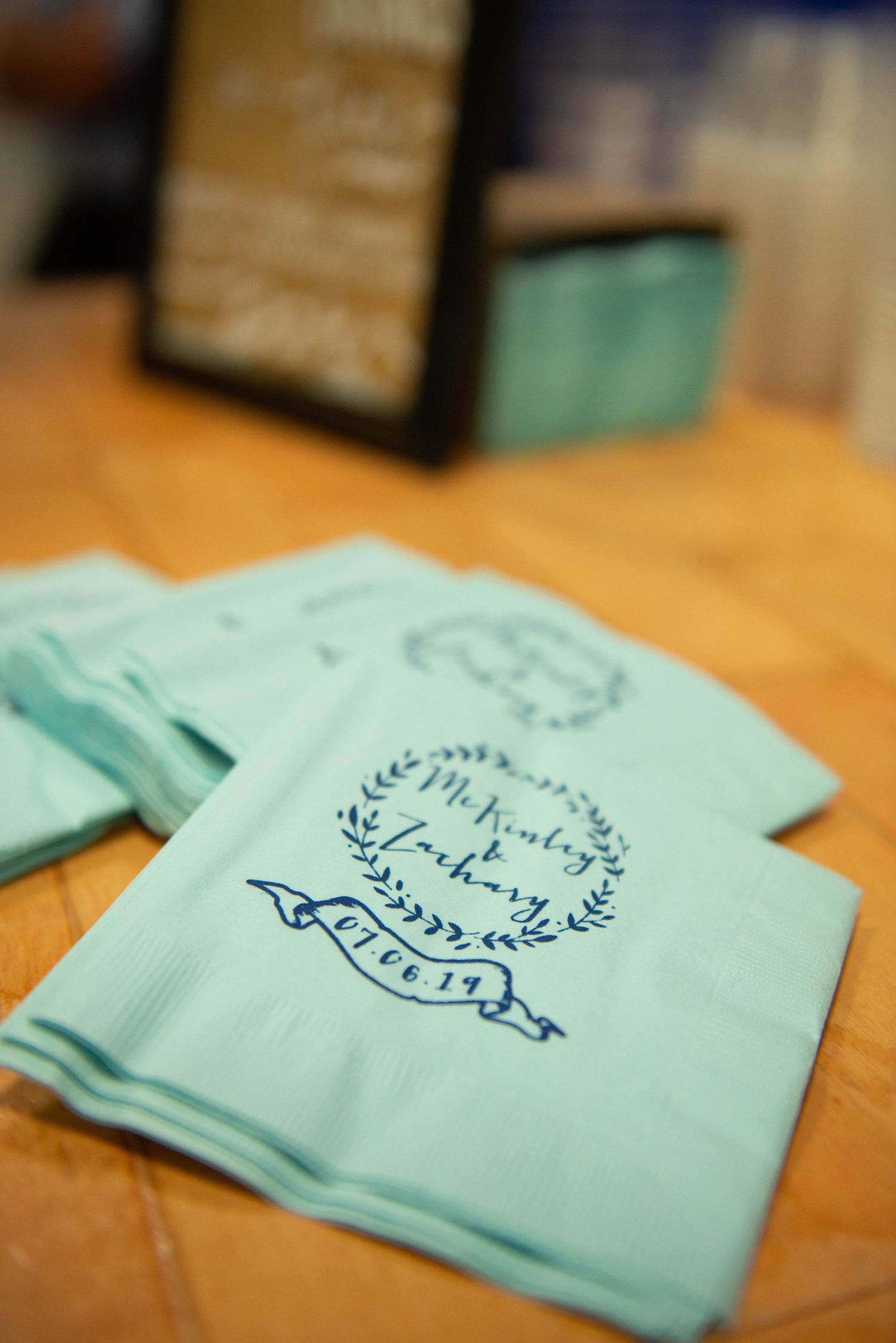 Close-up shots of mint colored napkins with decorative text and floral designs. Zimmerman MN Weddings