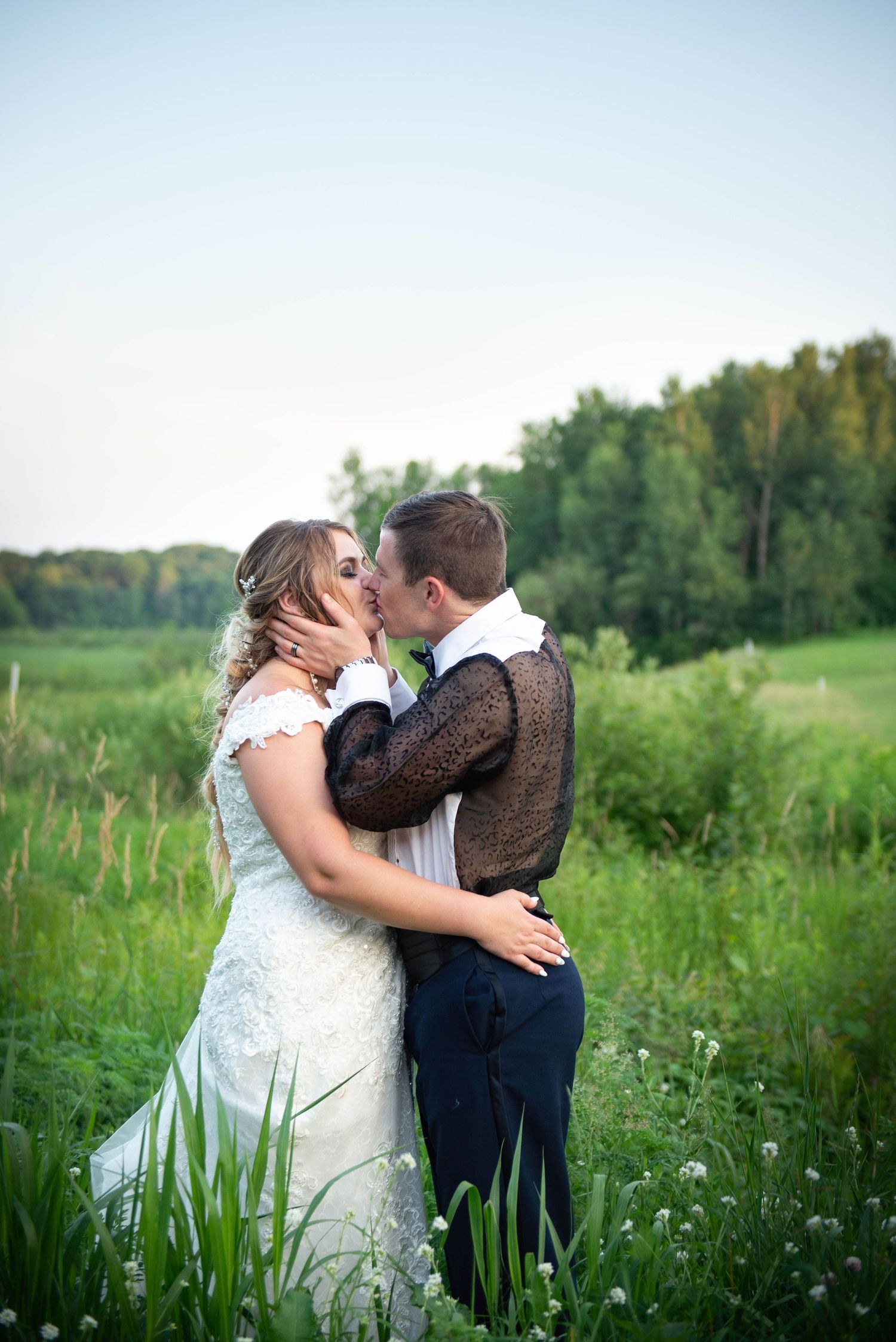 A romantic wedding kiss between newlyweds in a wildflower meadow during golden hour.  Zimmerman MN Weddings