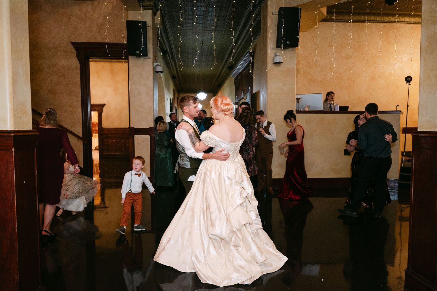 Central MN Wedding Photos | Bride and groom share first dance on reflective floor at elegant wedding reception.