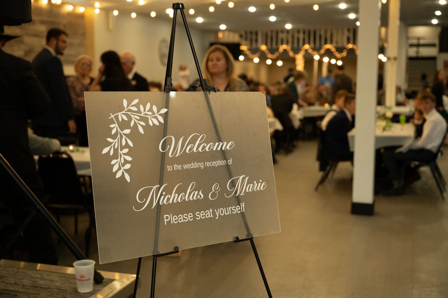 Six elegant welcome signs with snowflake designs illuminate a winter wedding reception venue.