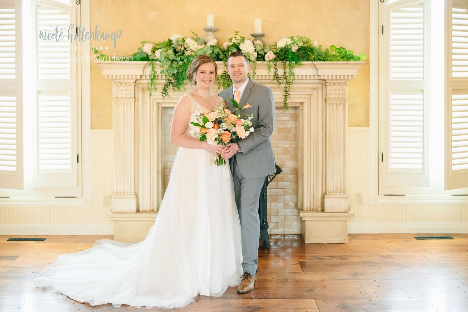 Bride and groom posing together in front of a floral-adorned fireplace in an elegant wedding venue. Crooked Willow Osakis