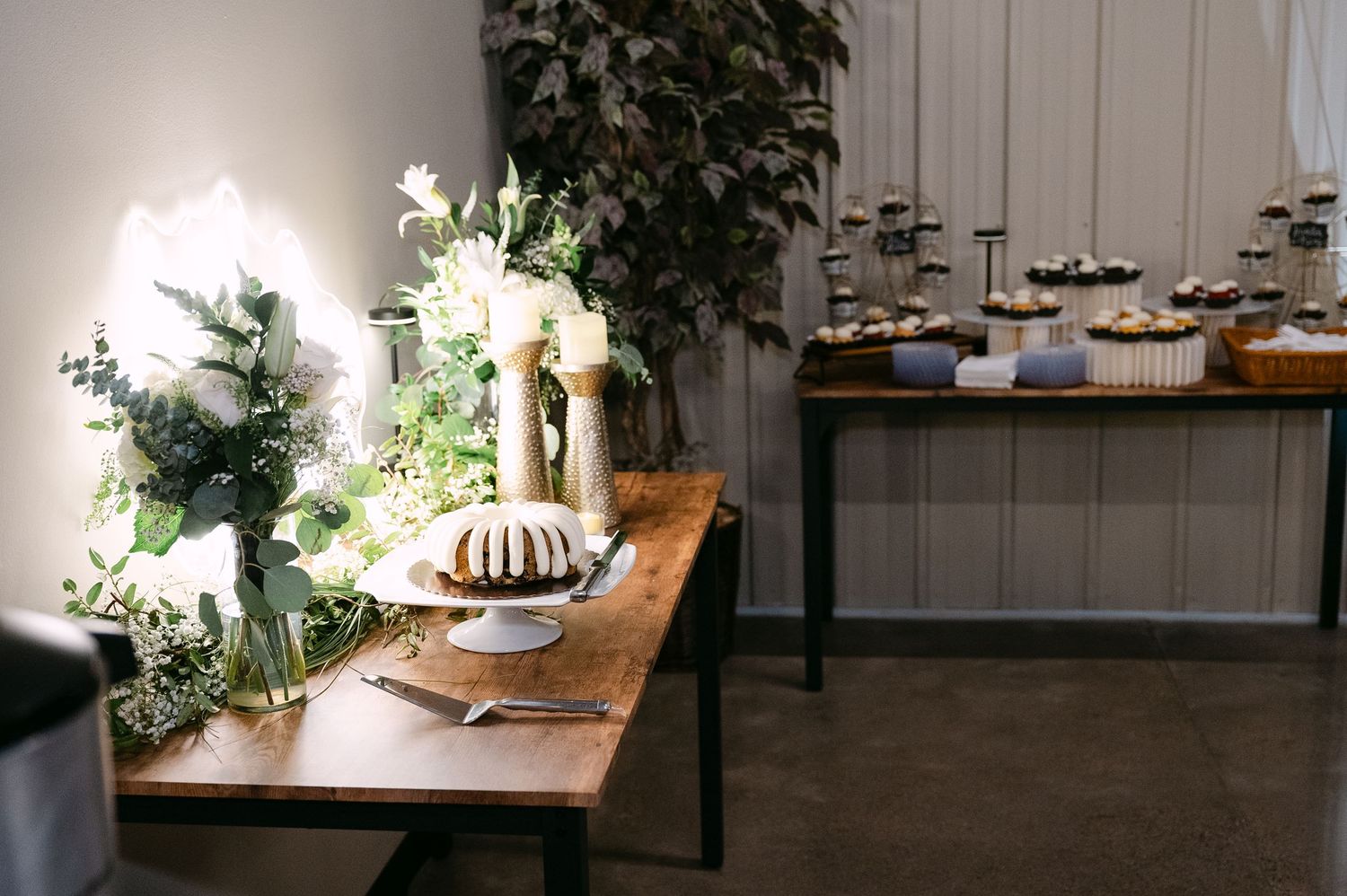 Modern wedding reception venue with wooden tables and minimalist white decor.