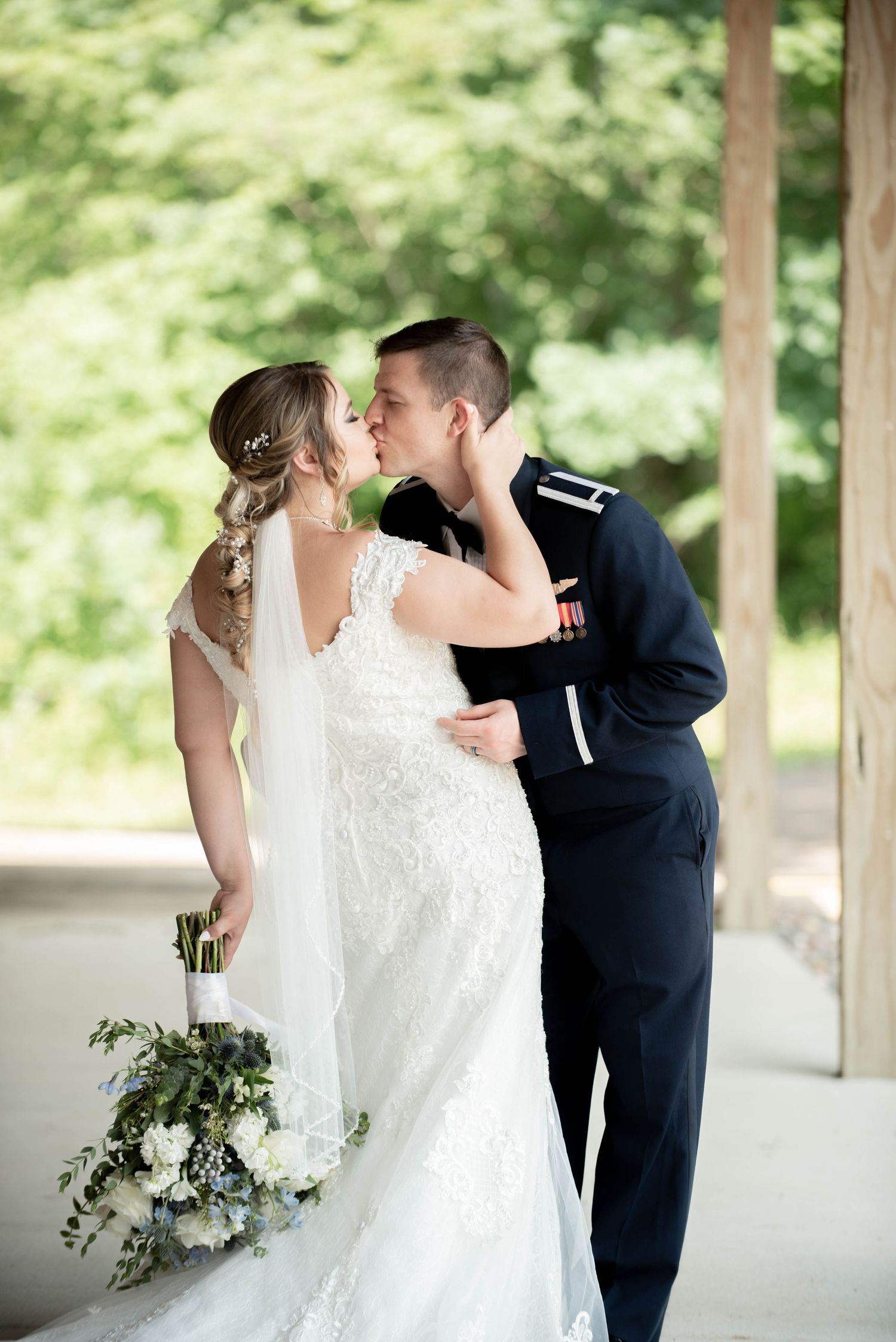 Romantic wedding moment captured under covered outdoor pavilion. Zimmerman MN Weddings