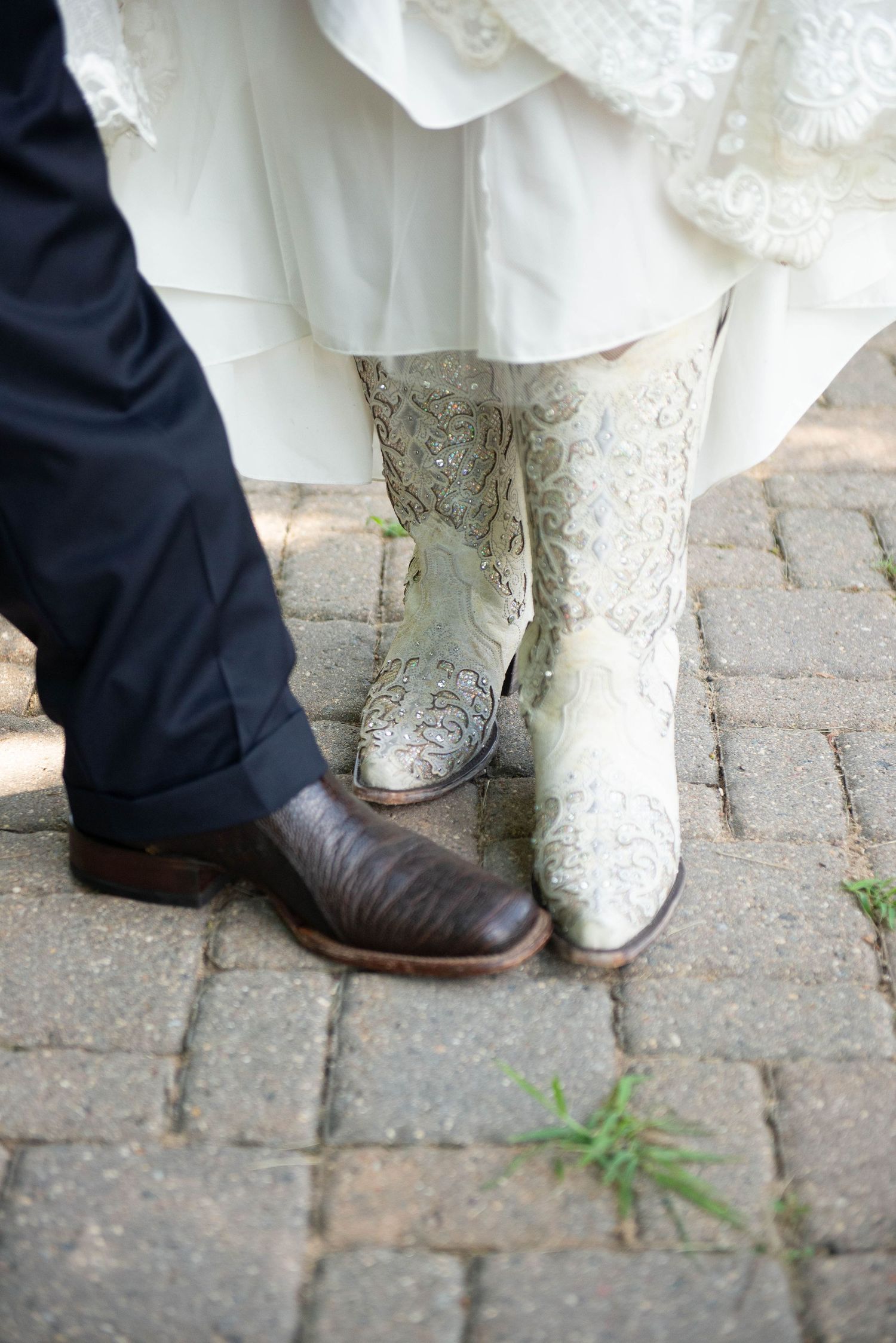 Close-up of bride and groom's boots on brick pavement showing wedding attire details. Zimmerman MN Weddings