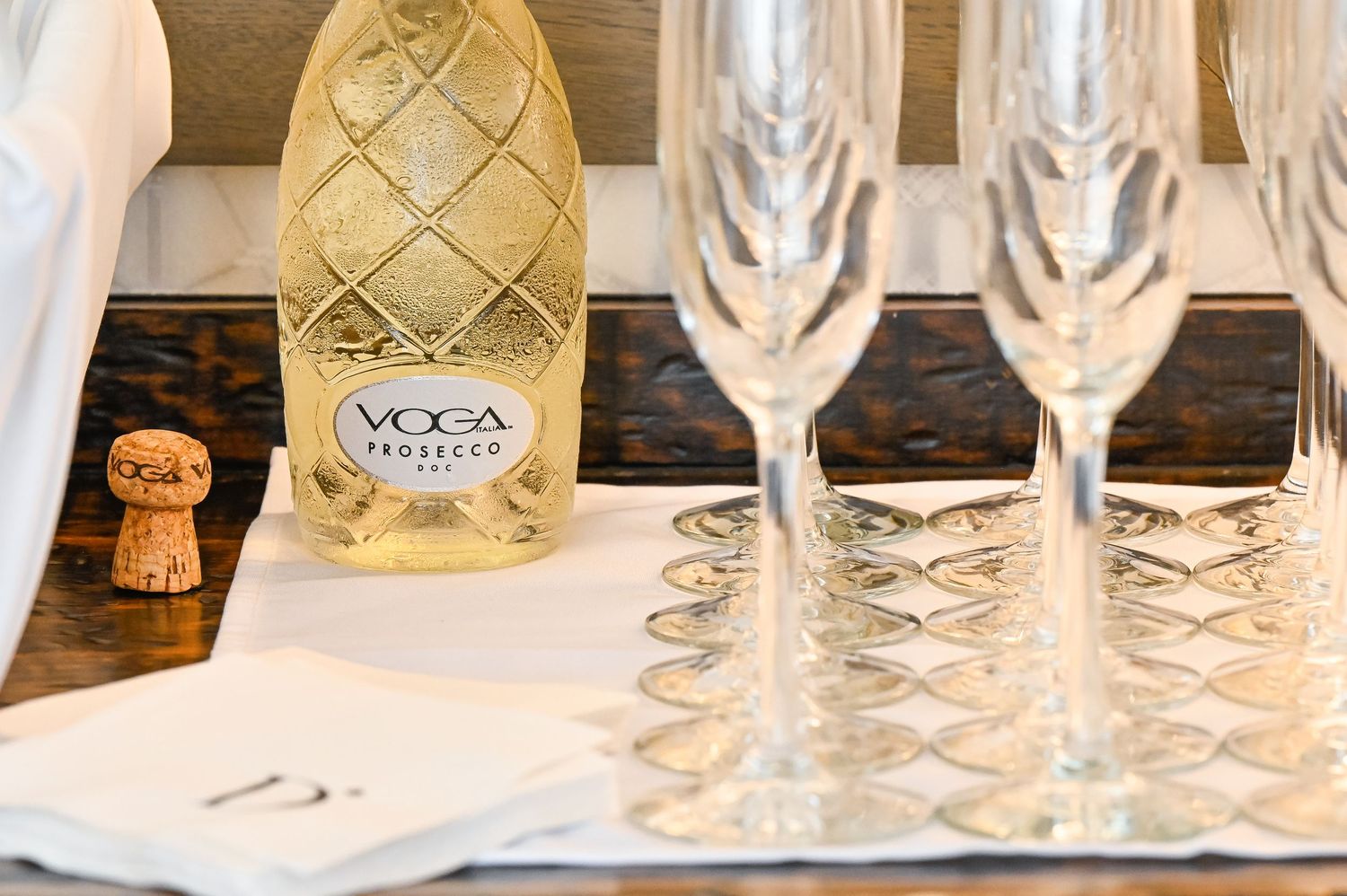 Wedding reception setup with champagne glasses and a decorative bottle on display.