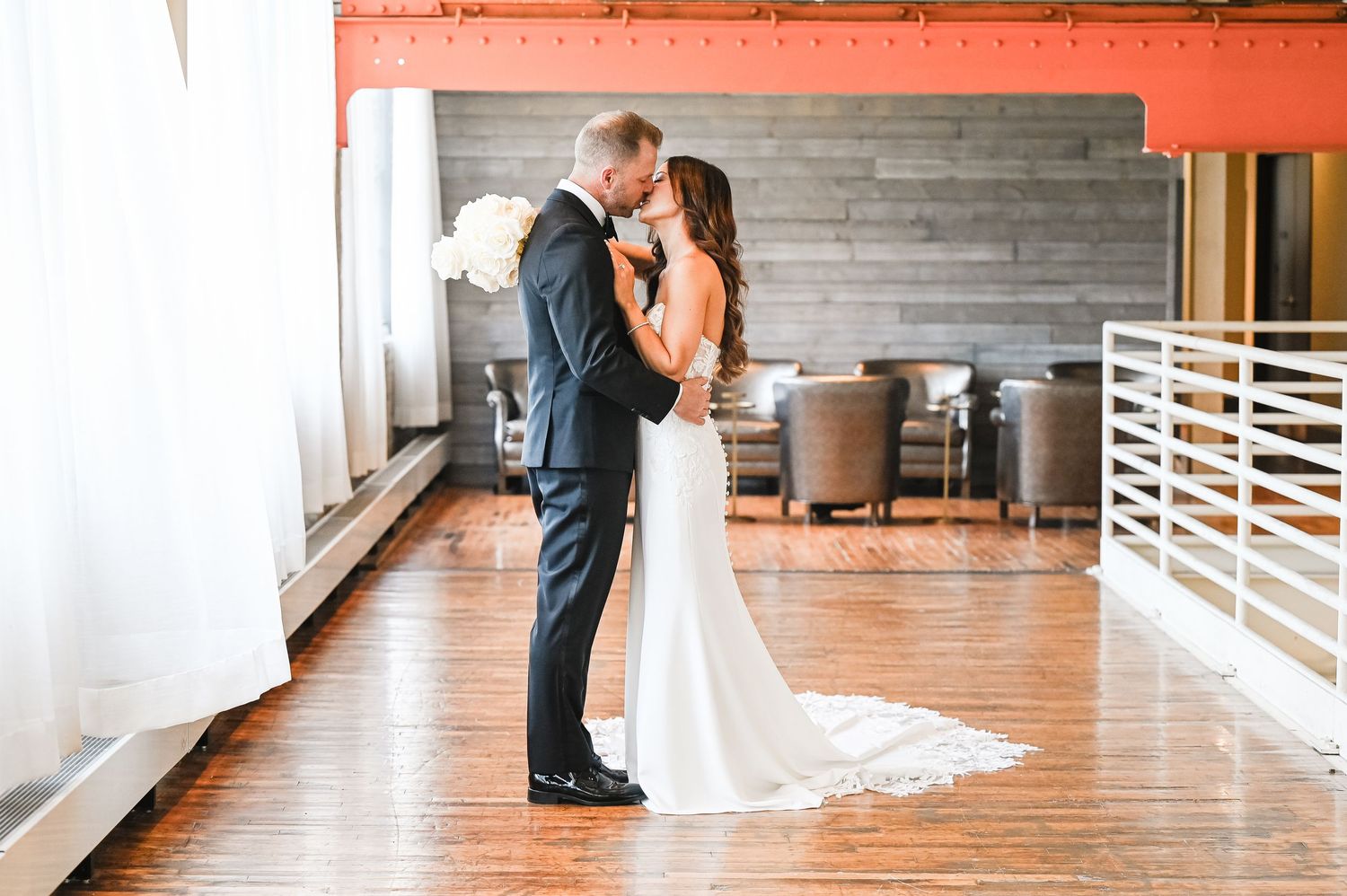 Romantic first look sequence in a bright industrial space with wooden floors.