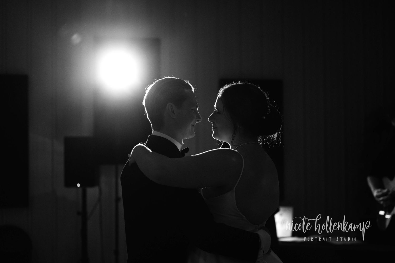 A silhouetted couple shares an intimate moment during their first dance at a wedding reception with dramatic backlighting at Heart and Soul