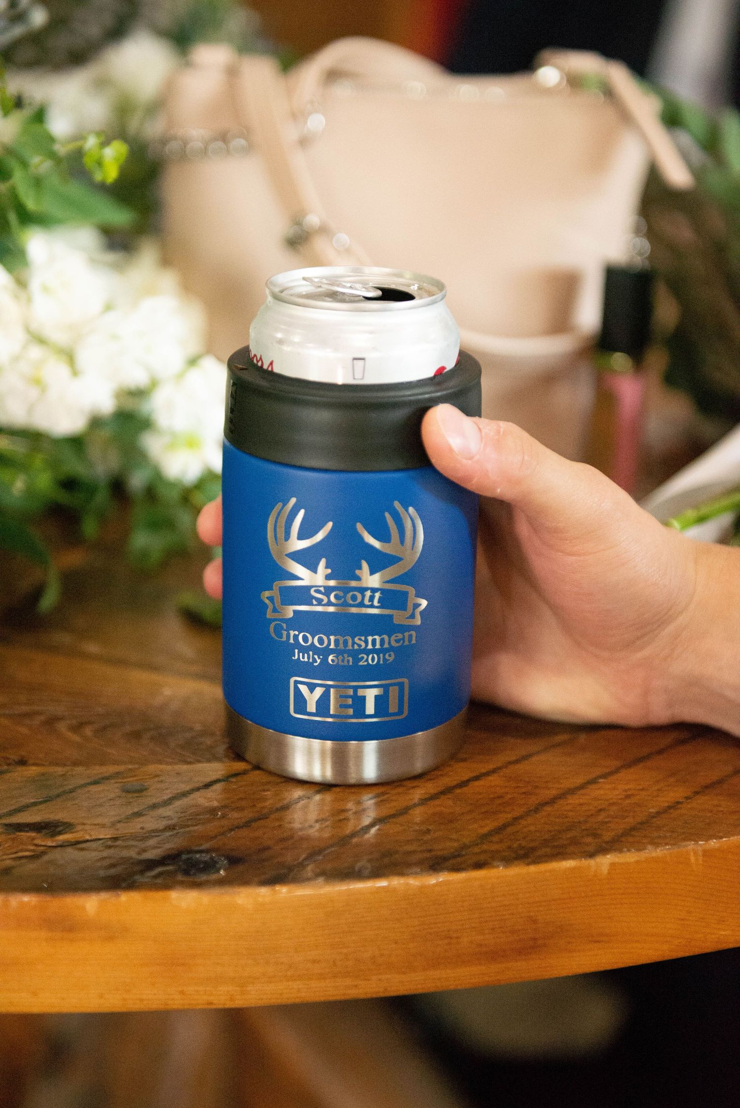 Blue metal YETI tumblers with antler logo designs displayed on wooden table. Zimmerman MN Weddings