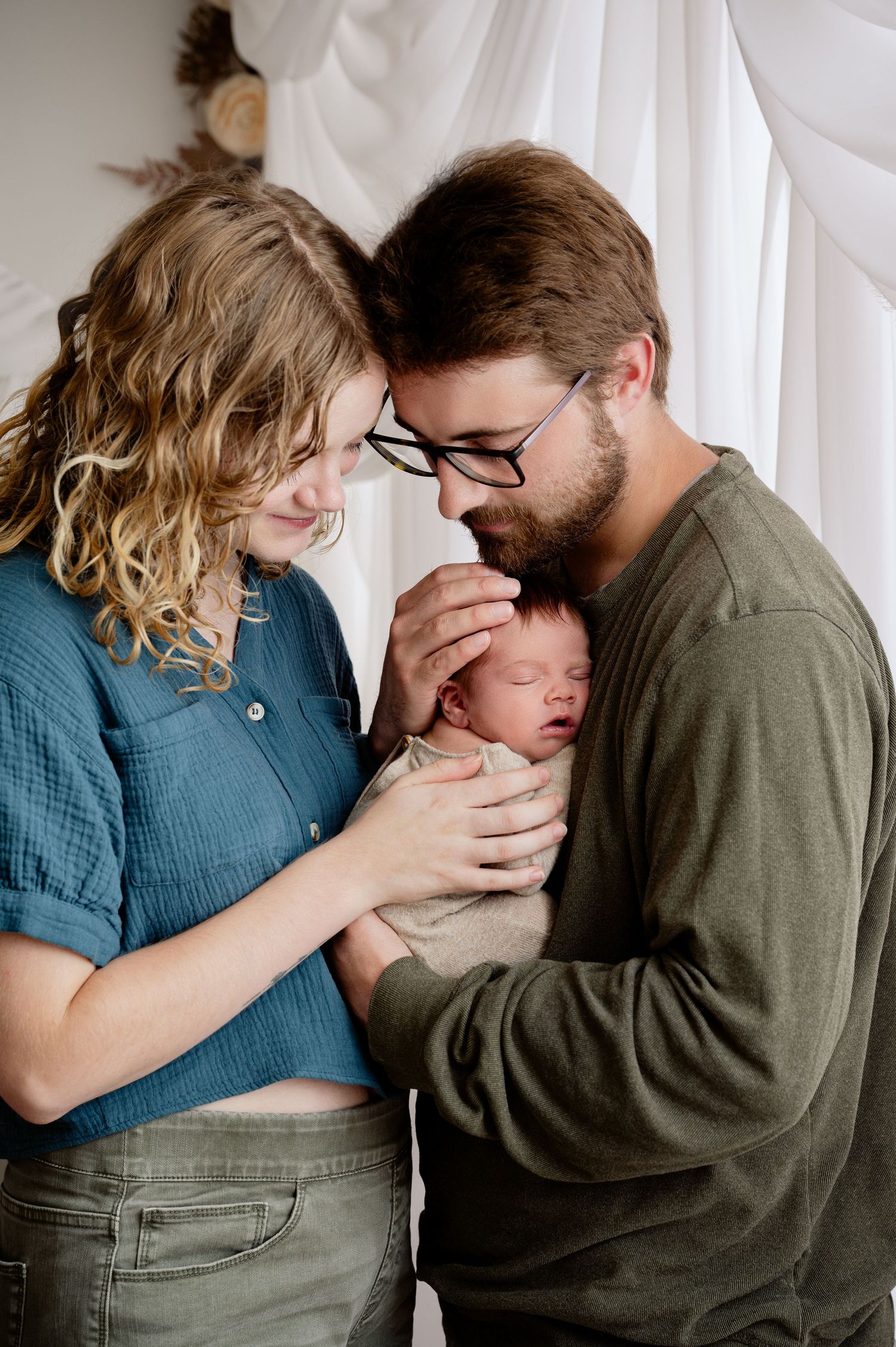 Minnesota Best newborn photographer - A couple share an intimate emotional moment in a series of candid photographs with their baby.