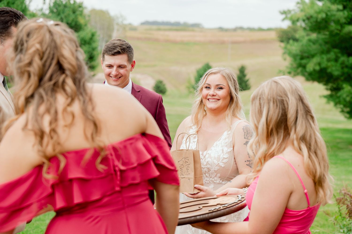 Wedding party members share laughs during outdoor celebration.