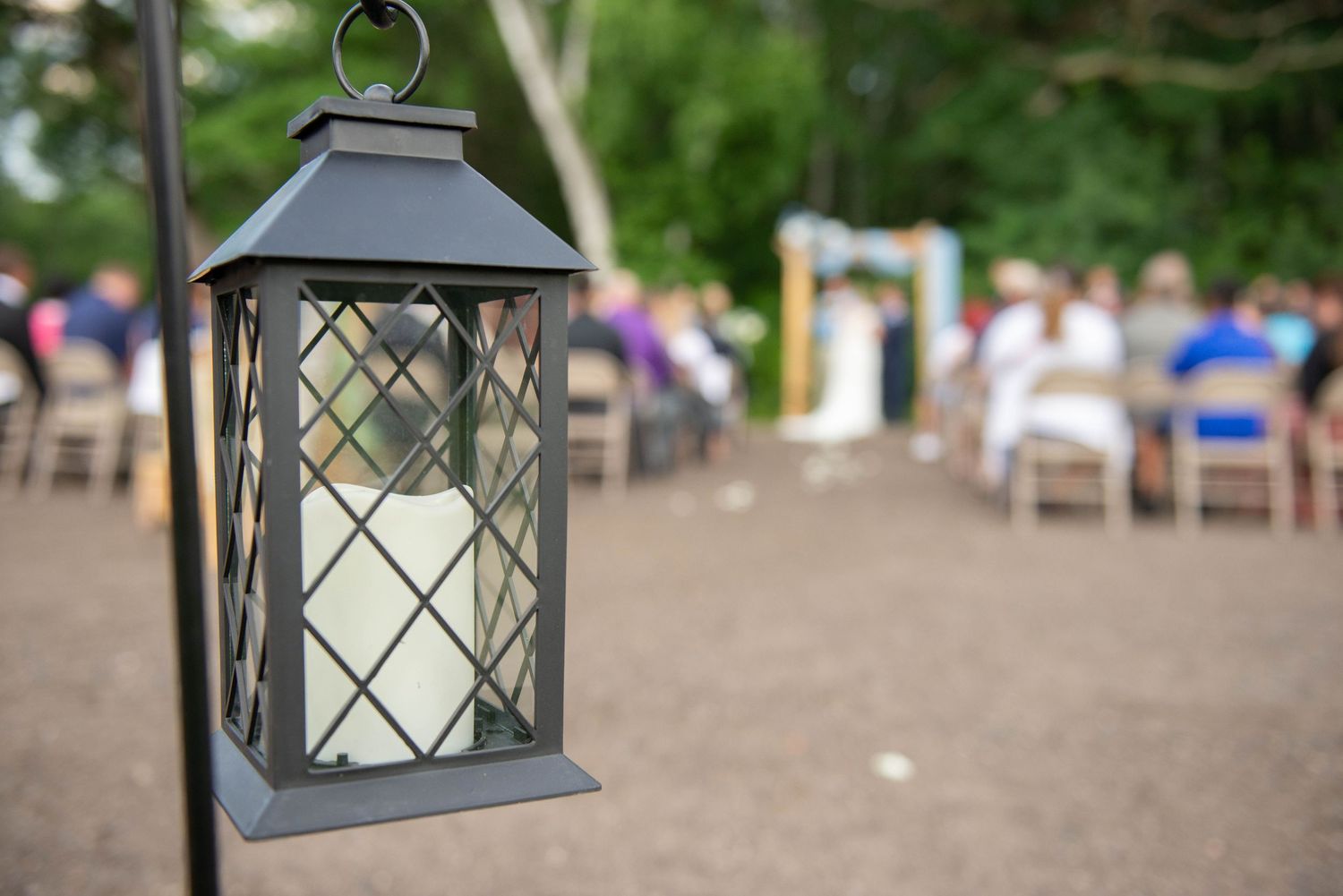 Black metal lanterns line a gravel path at an outdoor wedding venue. Zimmerman MN Weddings