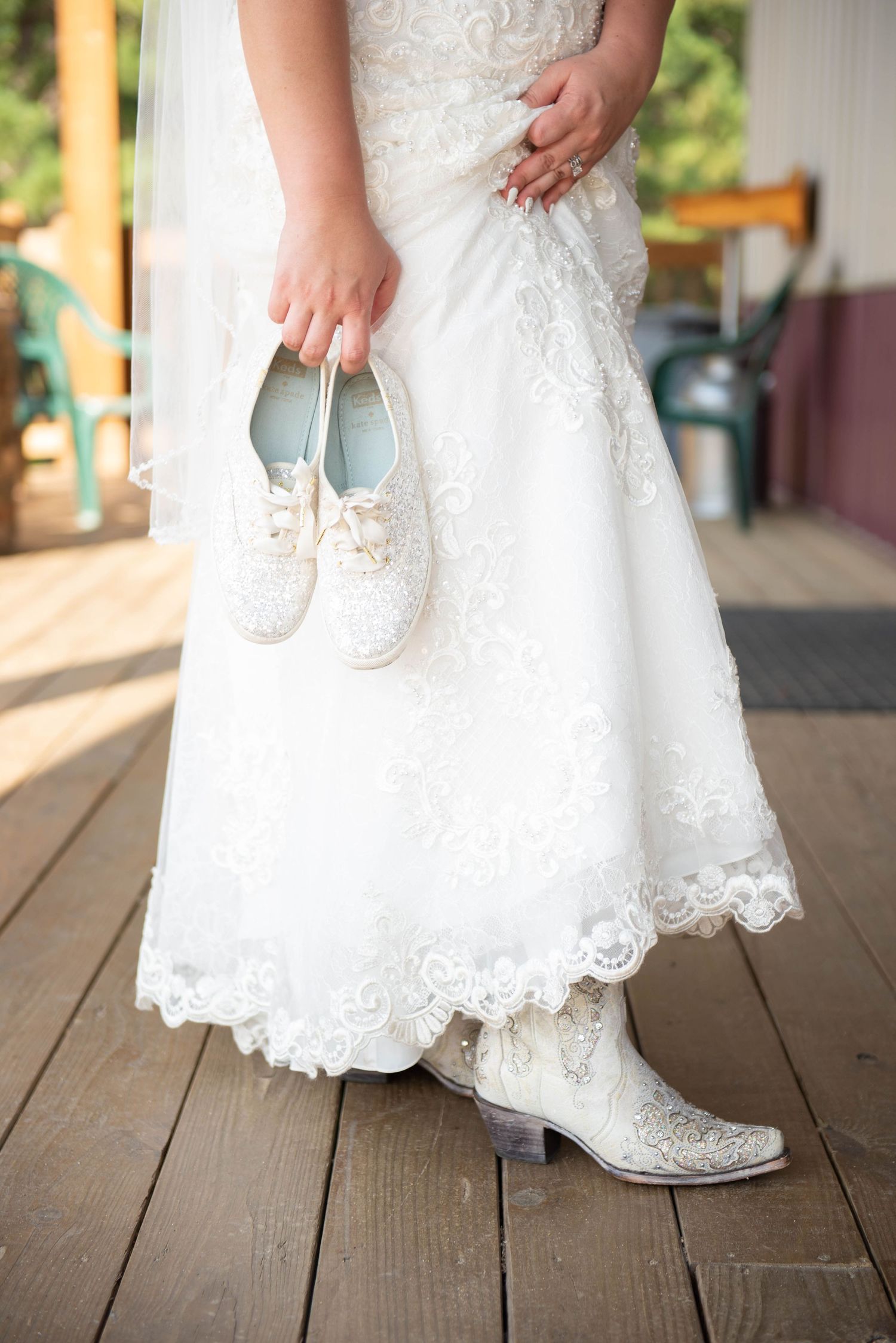 Close-up details of white lace wedding dress and shoes on a wooden deck. Zimmerman MN Weddings