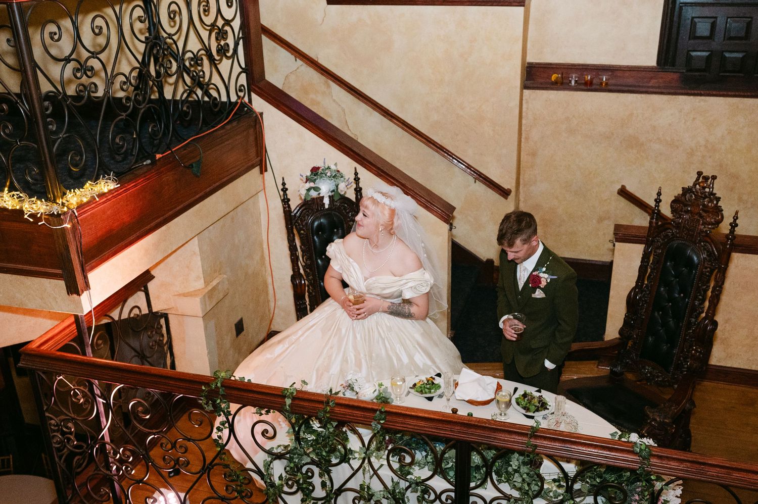 Central MN Wedding Photos | Bride and groom sitting together on an ornate staircase in a grand historic venue.