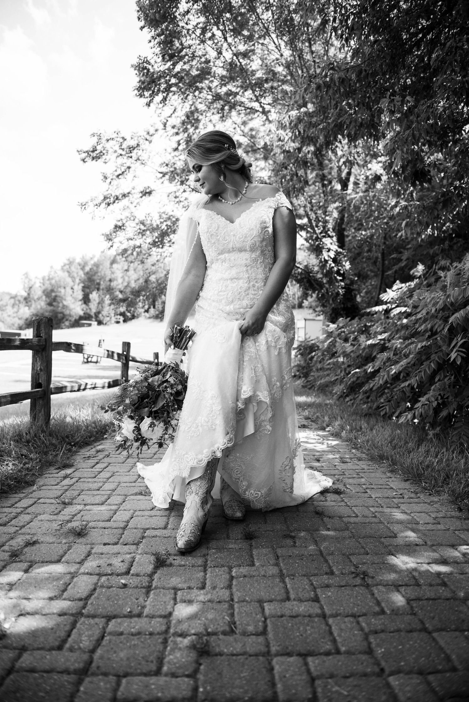 Black and white bridal portrait on brick pathway showing lace wedding dress details. Zimmerman MN Weddings