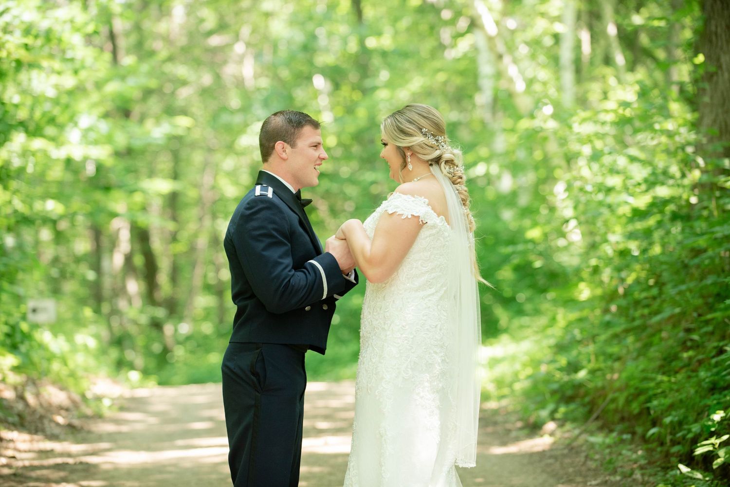 Romantic wedding portrait of couple in formal attire standing on forest path. Zimmerman MN Weddings