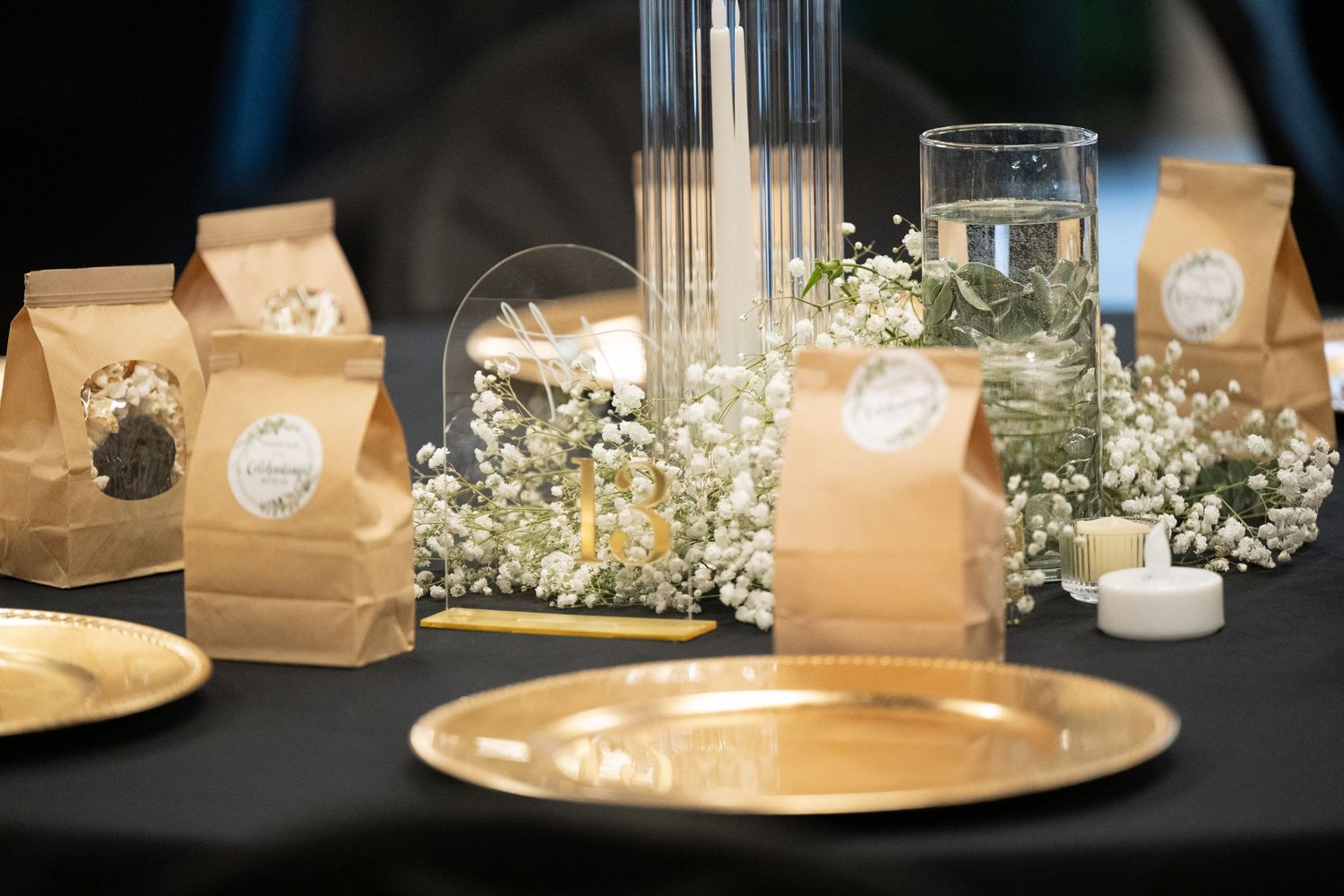 Wedding reception table decorated with brown paper bags and delicate baby's breath flowers.