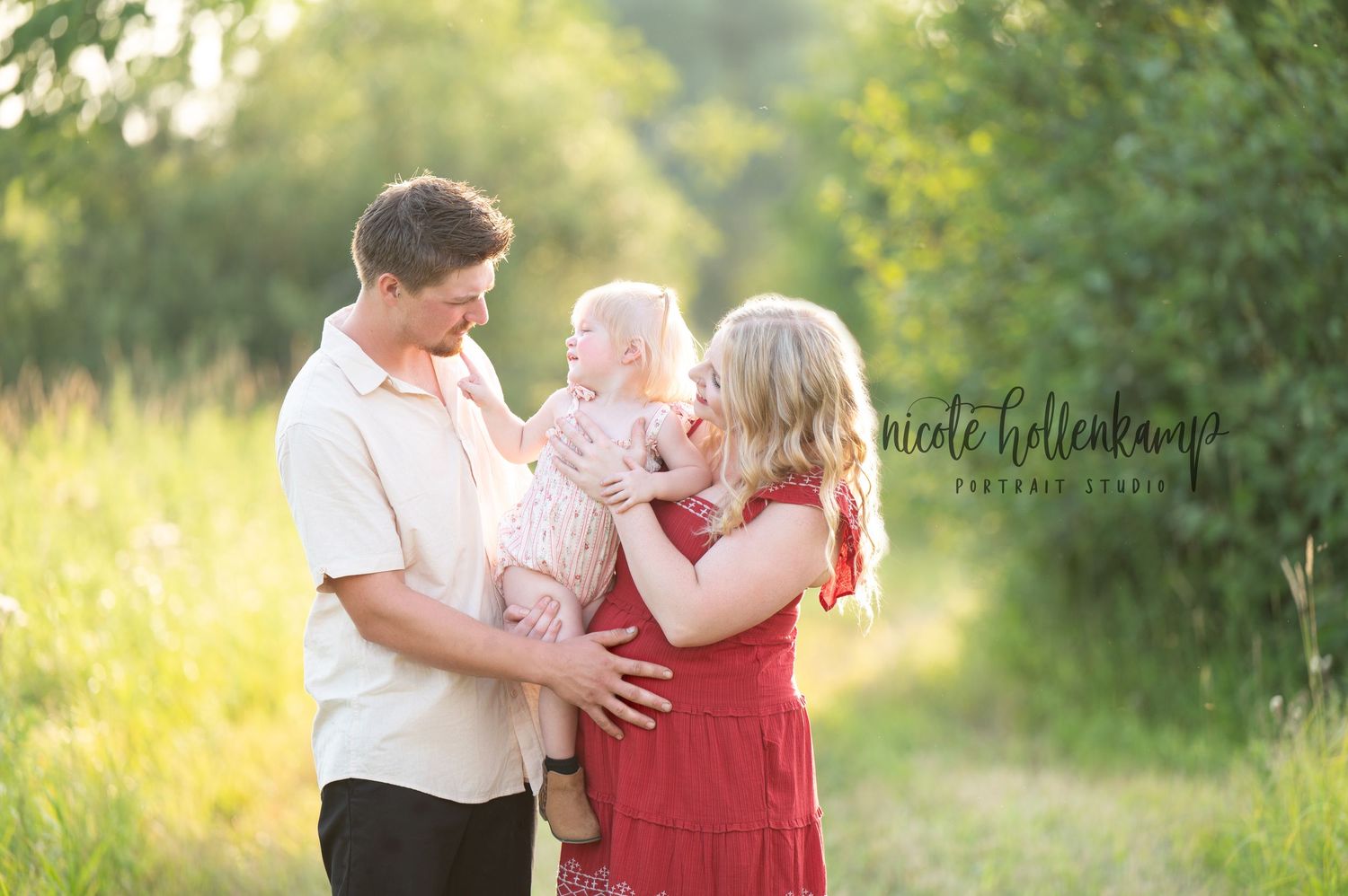 Happy family sharing joyful moment together in sunlit field at golden hour.
